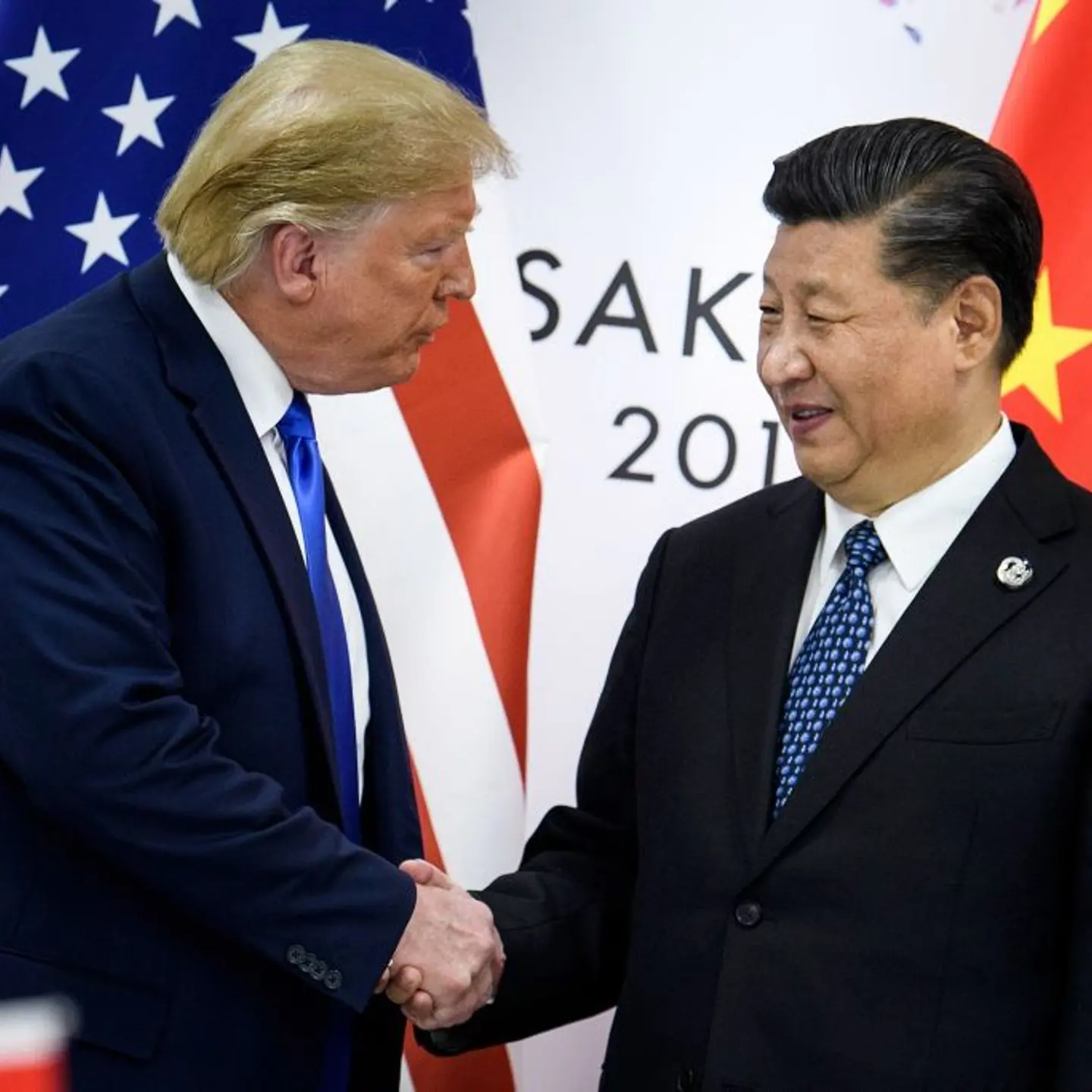China's President Xi Jinping (R) shakes hands with US President Donald Trump before a bilateral meeting on the sidelines of the G20 Summit in Osaka
