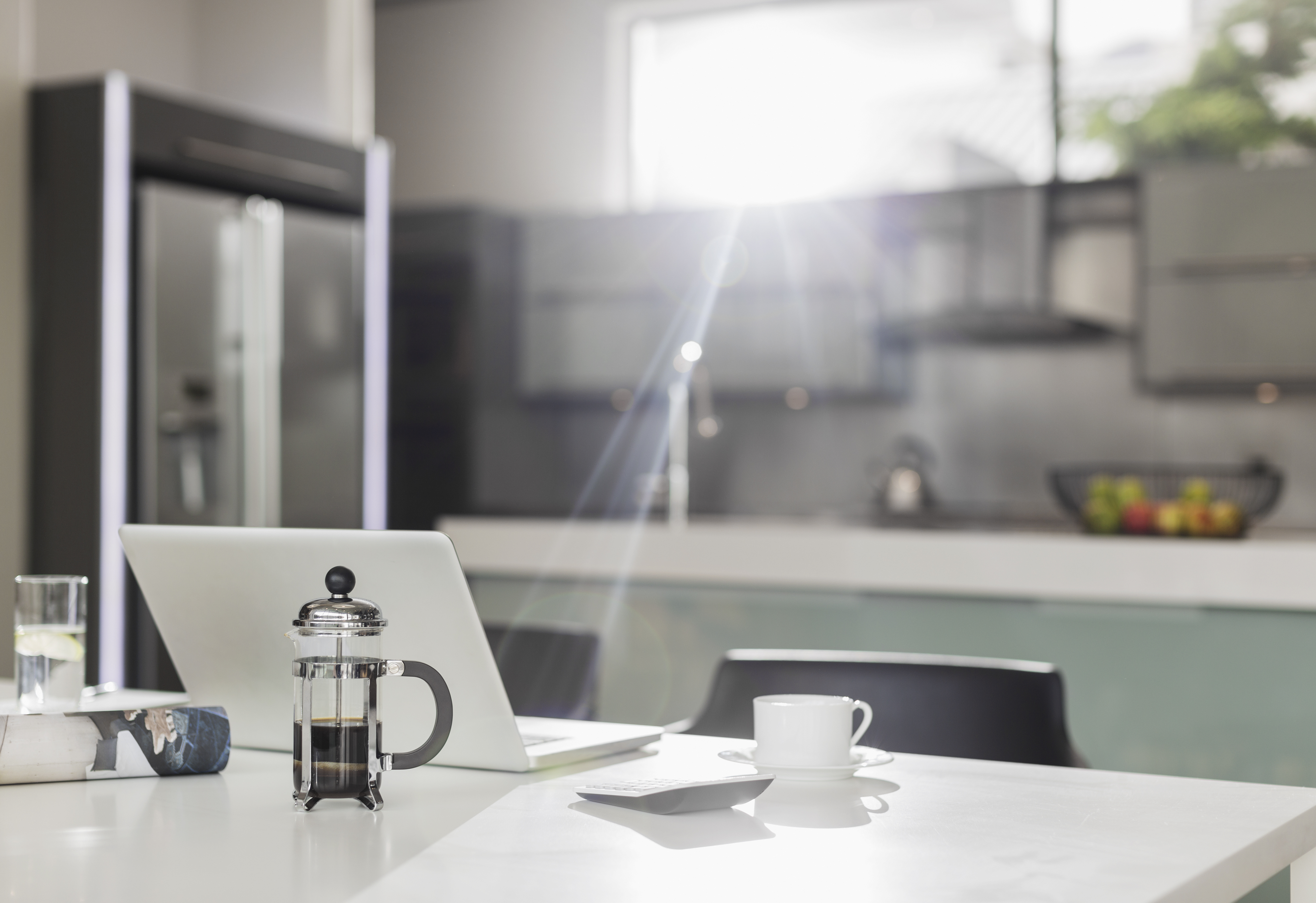 Morning sun shining on laptop in kitchen