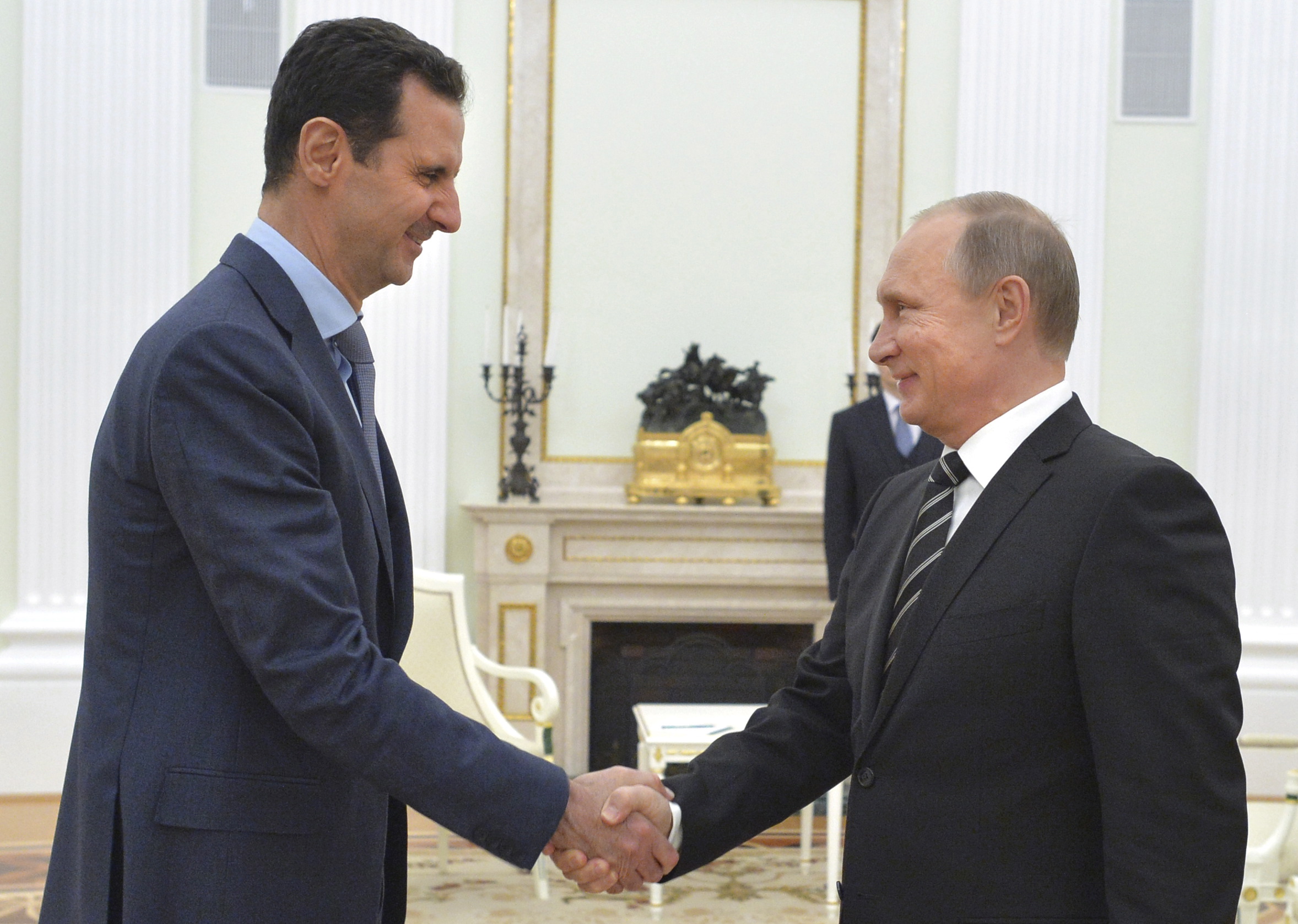 Russian President Putin shakes hands with Syrian President Assad during a meeting at the Kremlin in Moscow