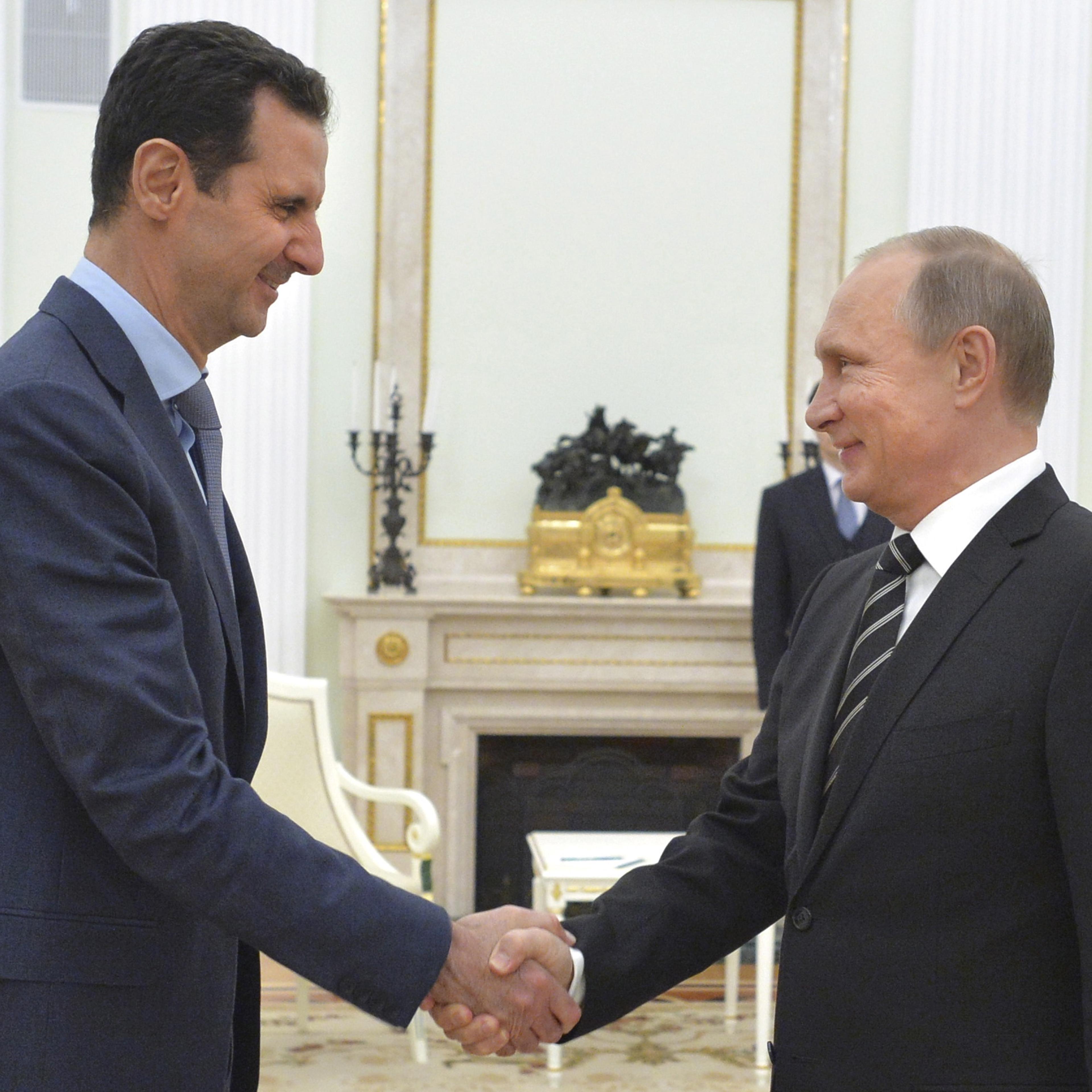 Russian President Putin shakes hands with Syrian President Assad during a meeting at the Kremlin in Moscow