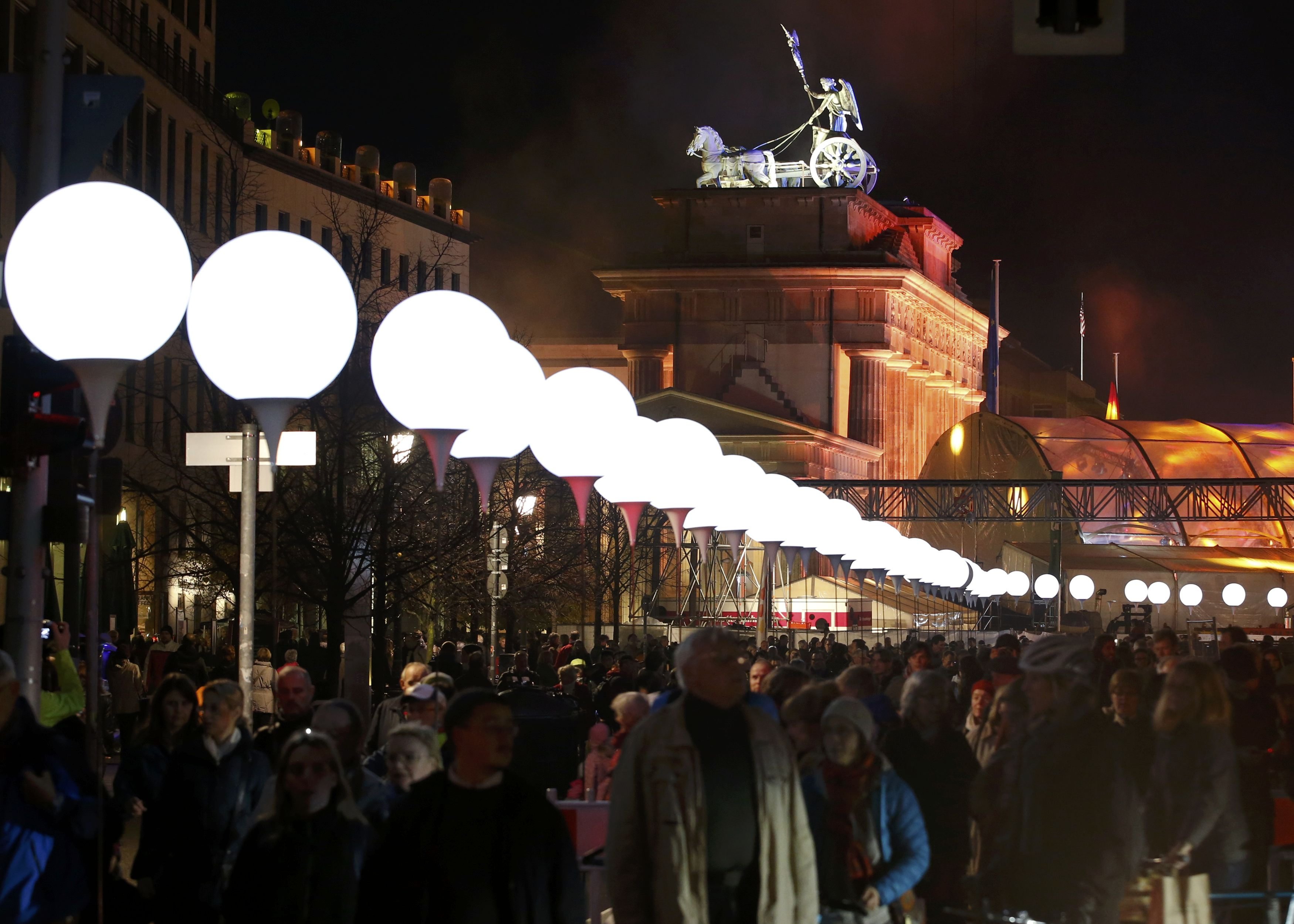 Lit balloons are placed along the former Berlin Wall location near the Brandenburg Gate in Berlin