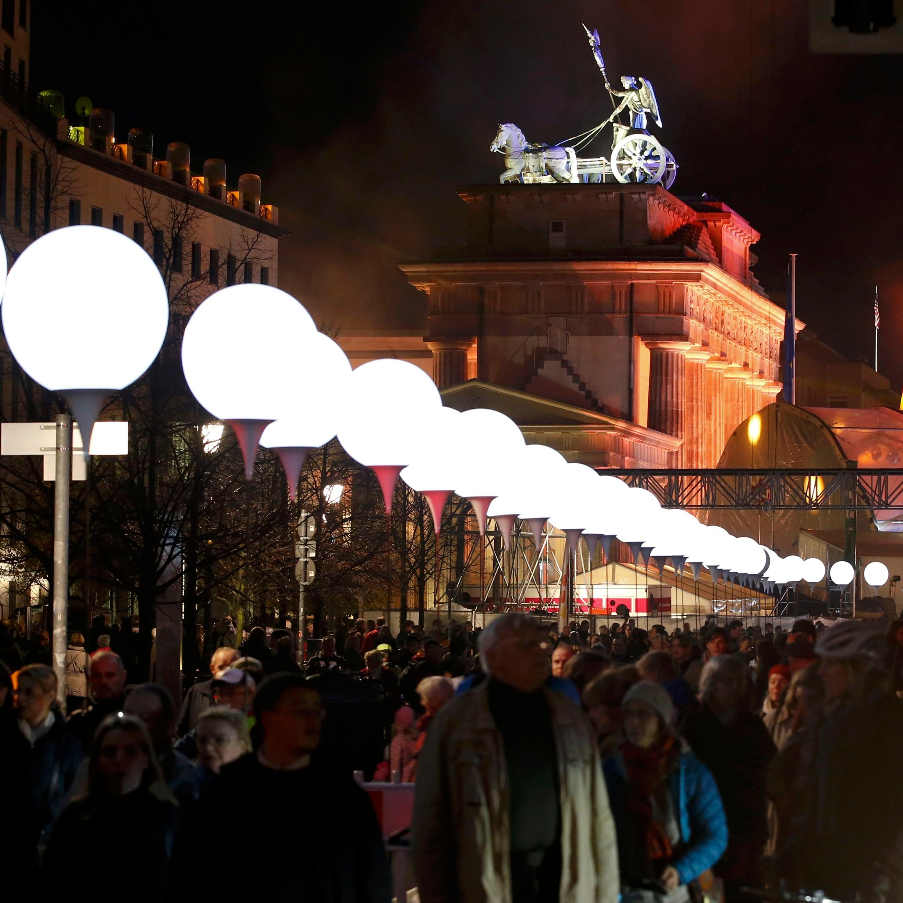 Lit balloons are placed along the former Berlin Wall location near the Brandenburg Gate in Berlin