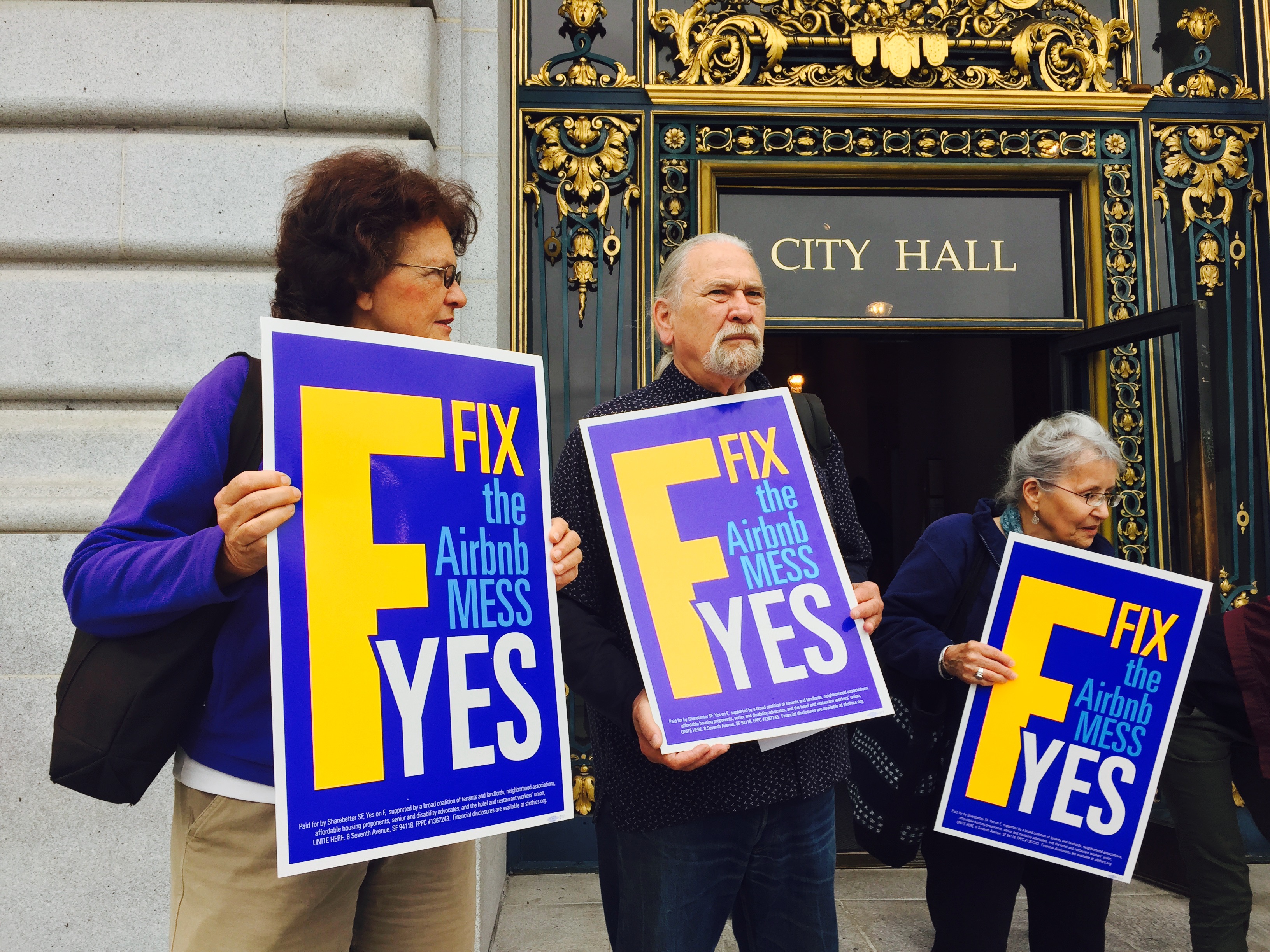 Supporters of a proposition that would place stricter limits on how often residents can rent out homes or rooms on Airbnb stand on the steps of San Francisco's city hall on Sept. 30, 2015. 