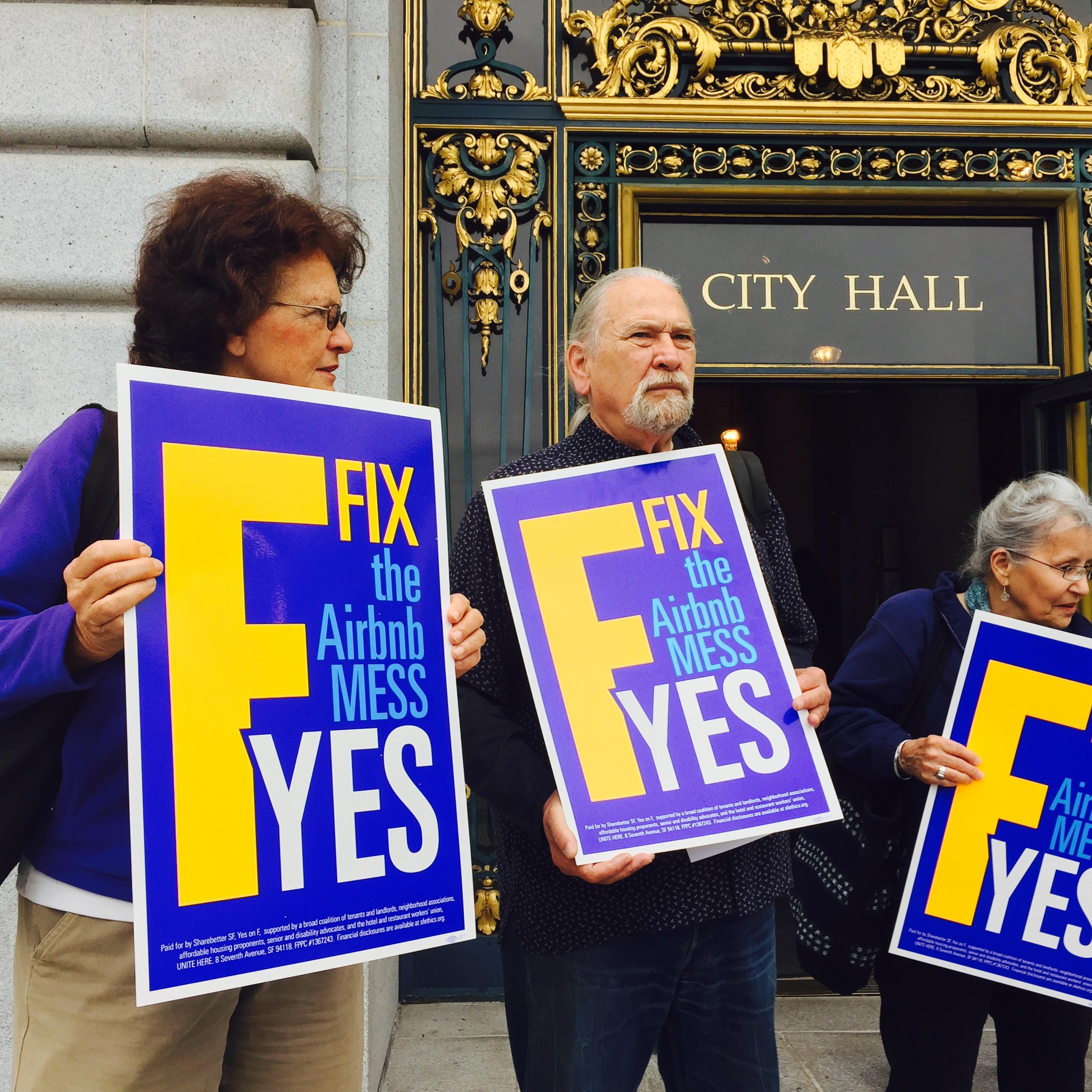 Supporters of a proposition that would place stricter limits on how often residents can rent out homes or rooms on Airbnb stand on the steps of San Francisco's city hall on Sept. 30, 2015.