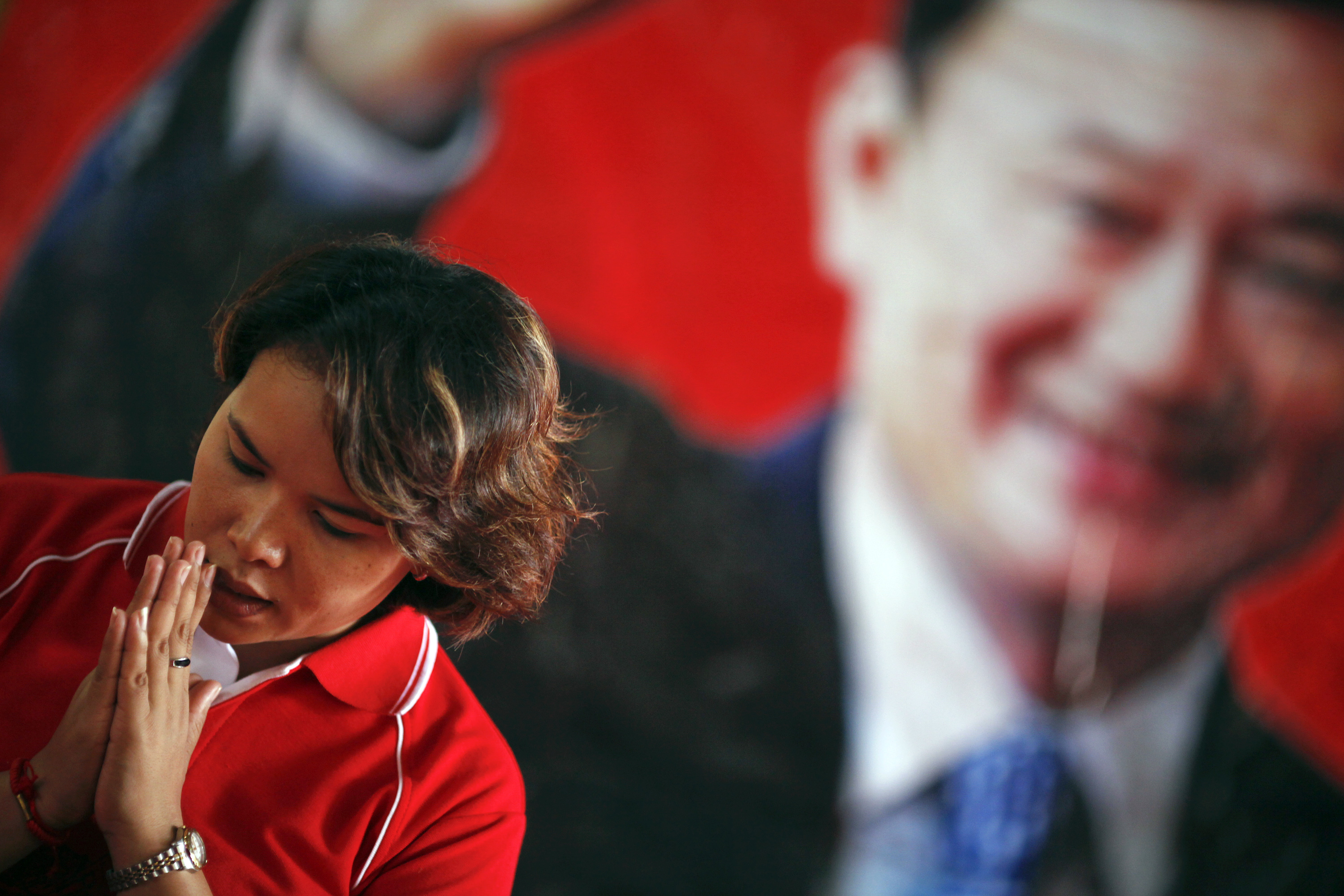A woman prays in front of a picture of ousted Thai Premier Thaksin Shinawatra during a religious ceremony at a temple in the village of Suan Mon near Udon Thani in northeastern Thailand.