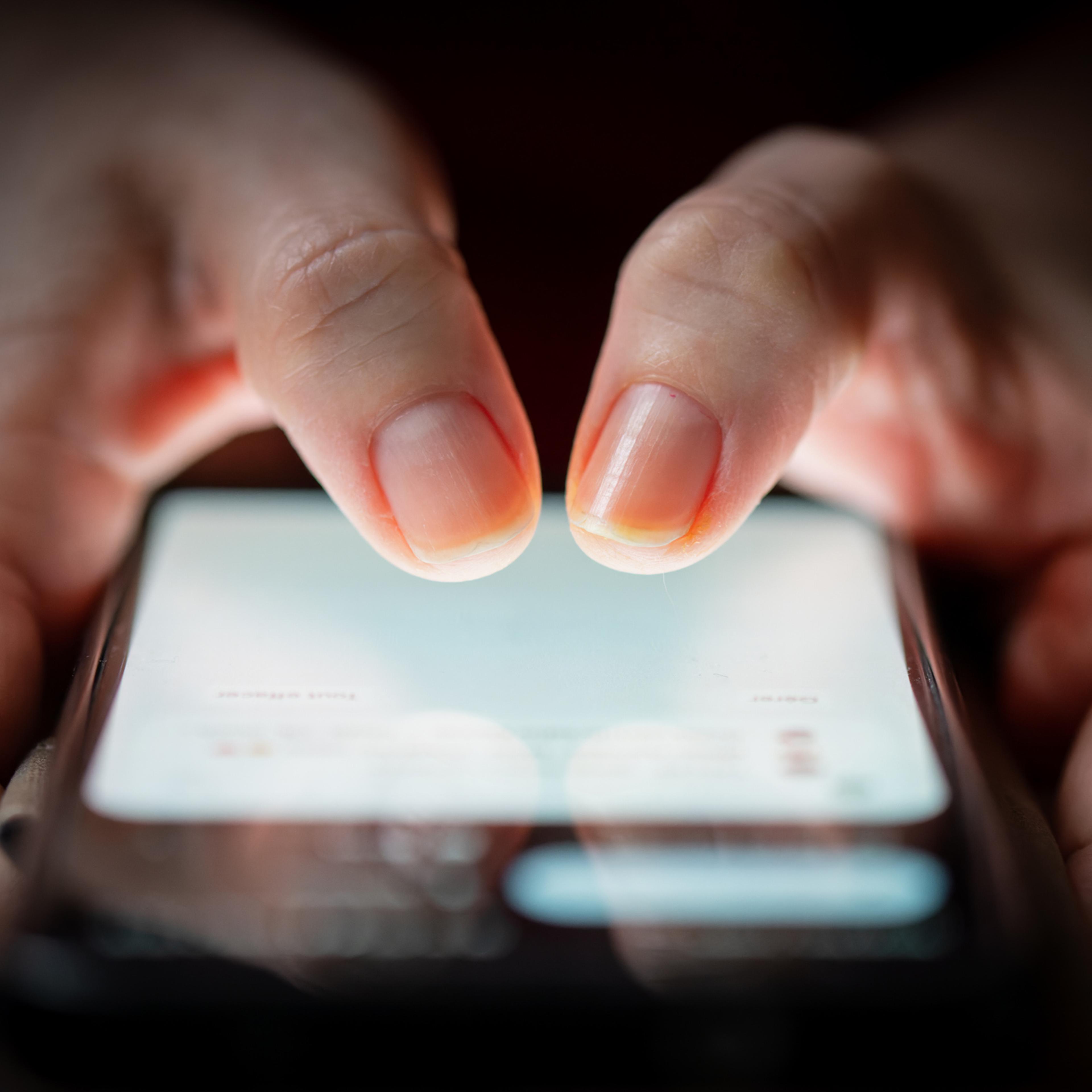 Fingers tapping smartphone screen