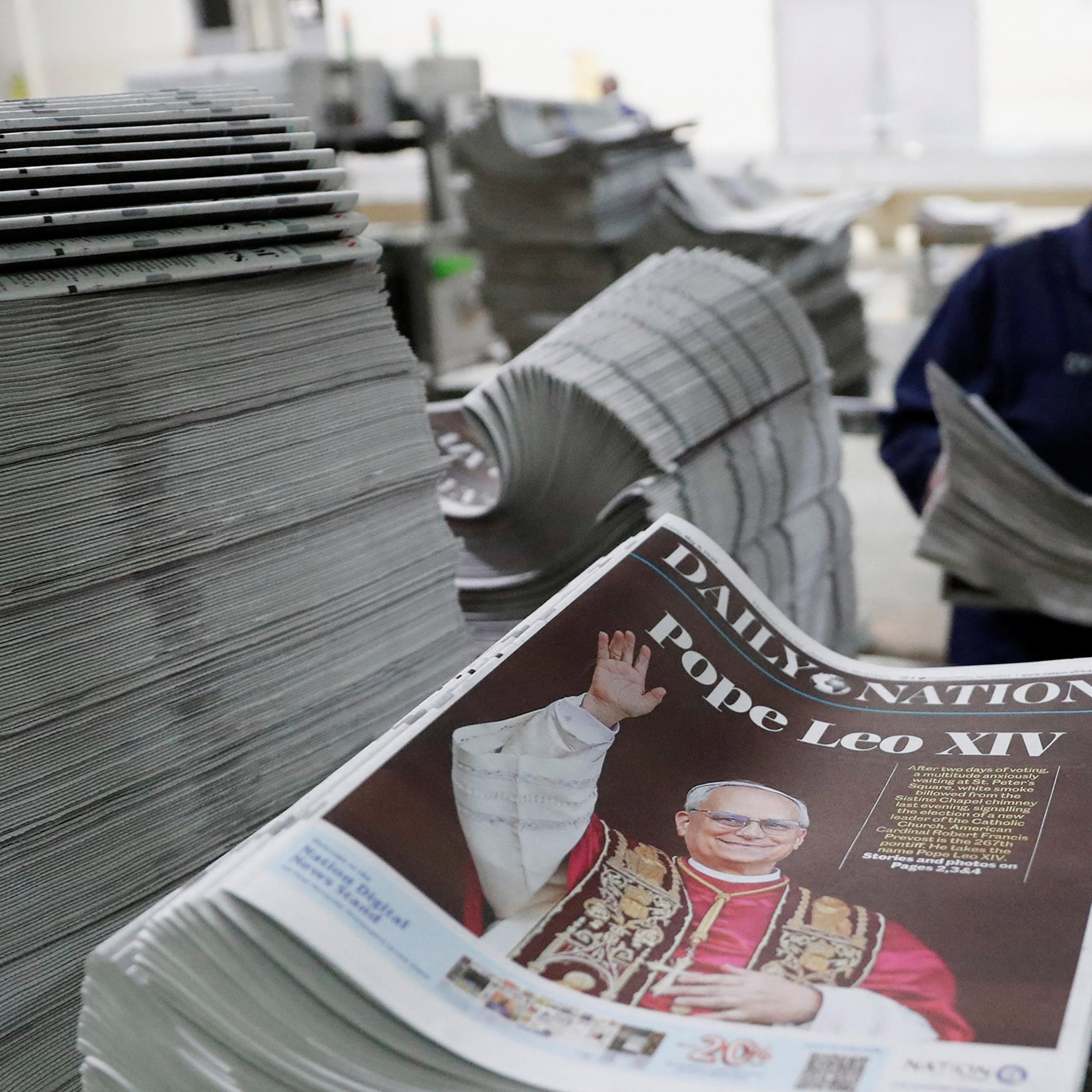 A worker arranges printed newspapers for circulation with a picture of the newly elected Pope Leo XIV at the Nation Media Group printing press on the outskirts of Nairobi, Kenya, May 8, 2025.
