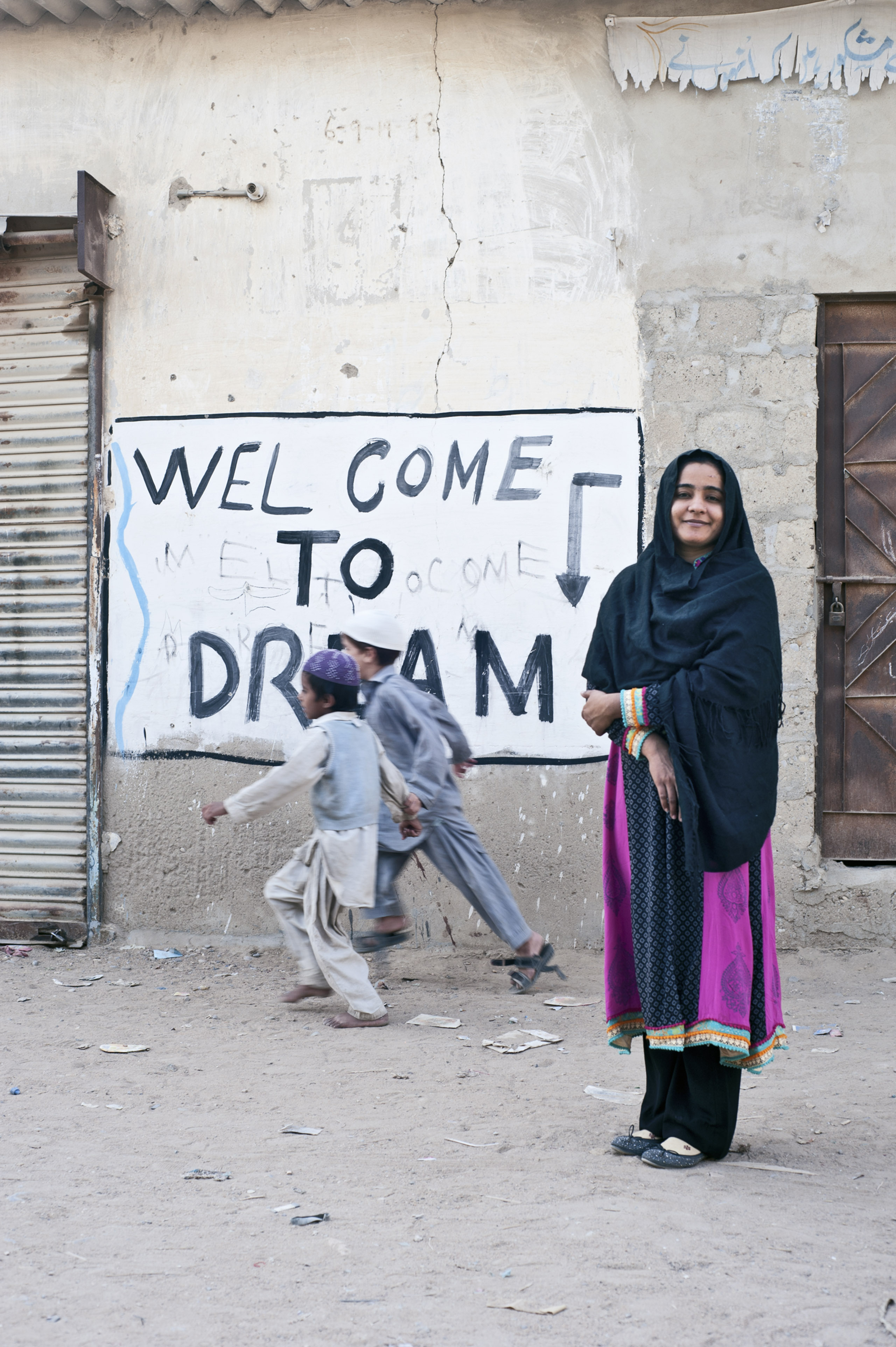 Bachal pauses outside her school in the settlement of Moach Goth, where she lives