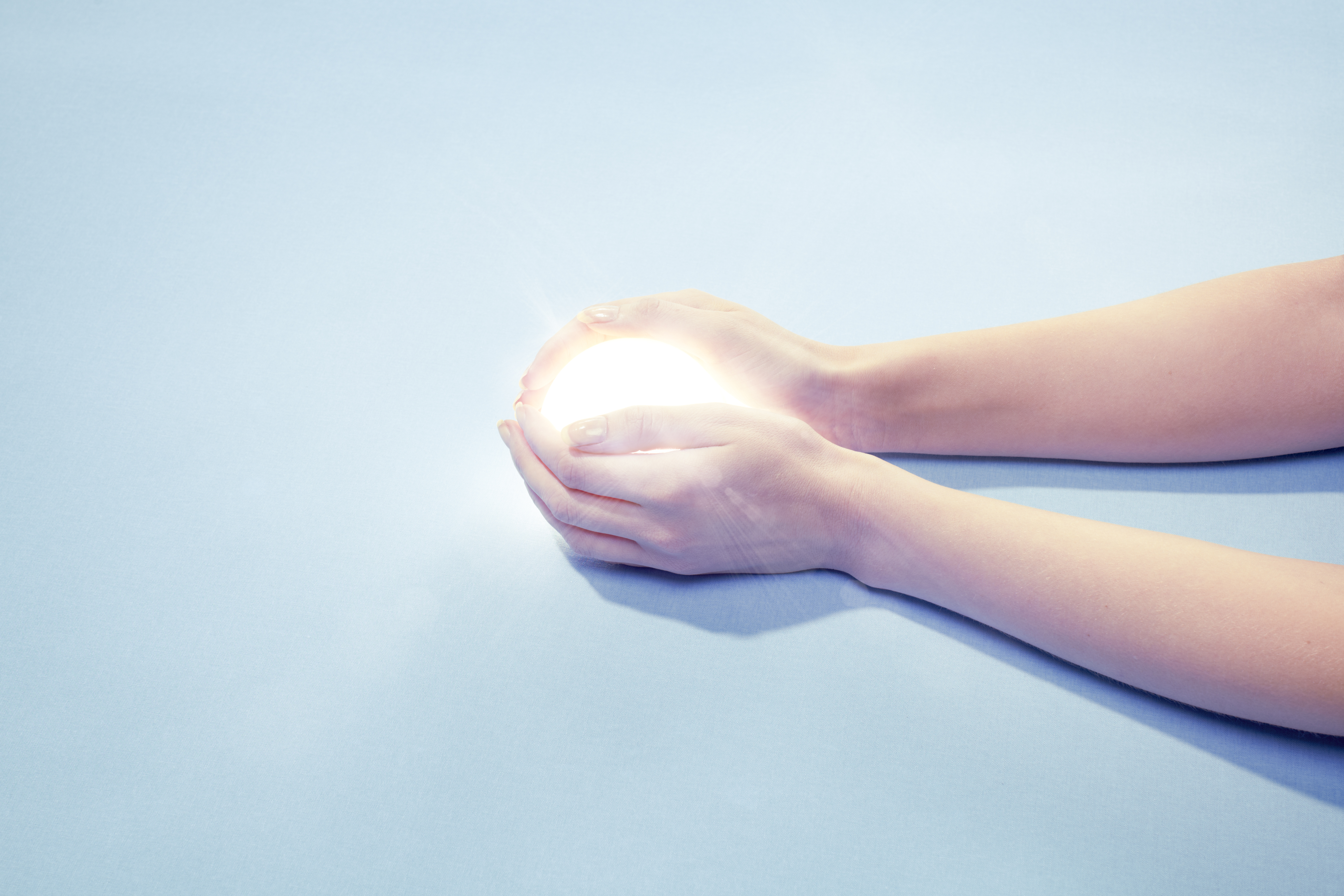 hand clasping globe of light