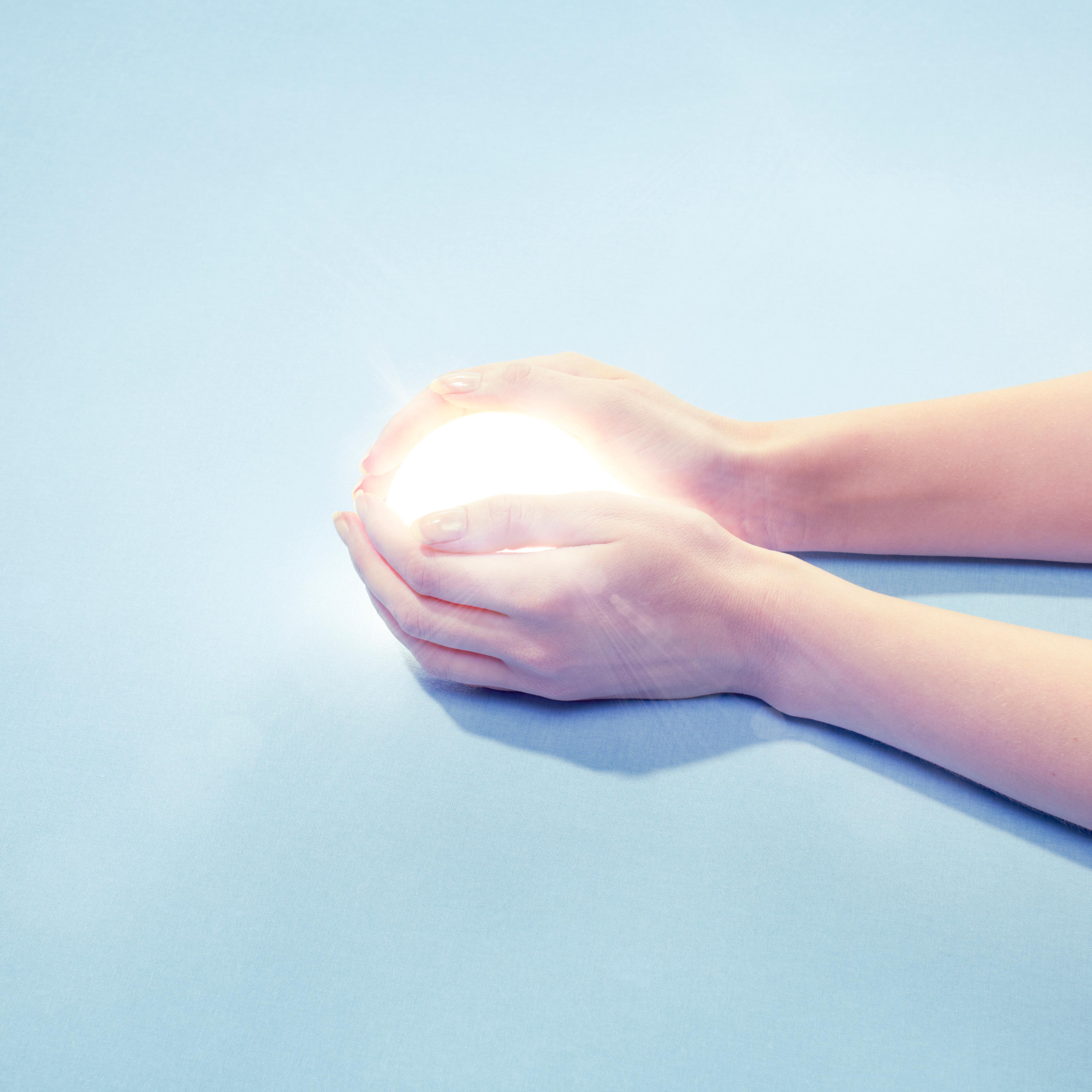 hand clasping globe of light