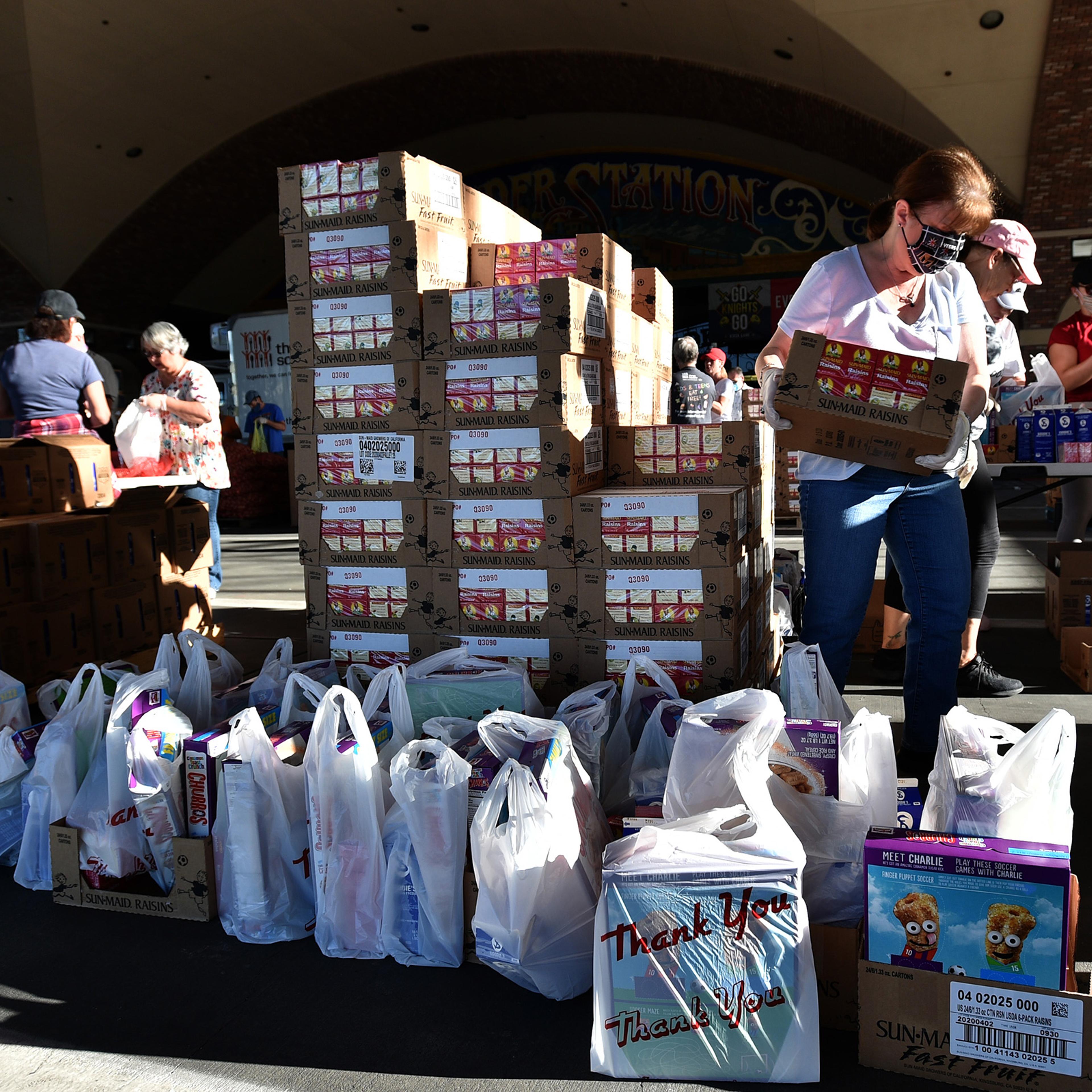 Volunteers prepare groceries to be given out at a drive-thru Three Square Food Bank emergency food distribution site at Boulder Station Hotel & Casino in response to an increase in demand amid the coronavirus pandemic on April 29 in Las Vegas.