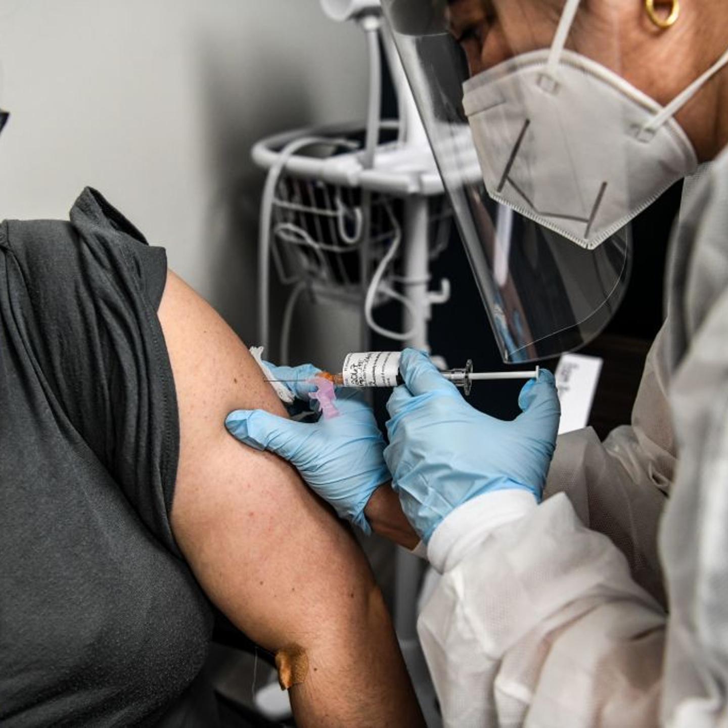 Heather Lieberman (L), 28, receives a COVID-19 vaccination from Yaquelin De La Cruz at the Research Centers of America in Hollywood, Florida