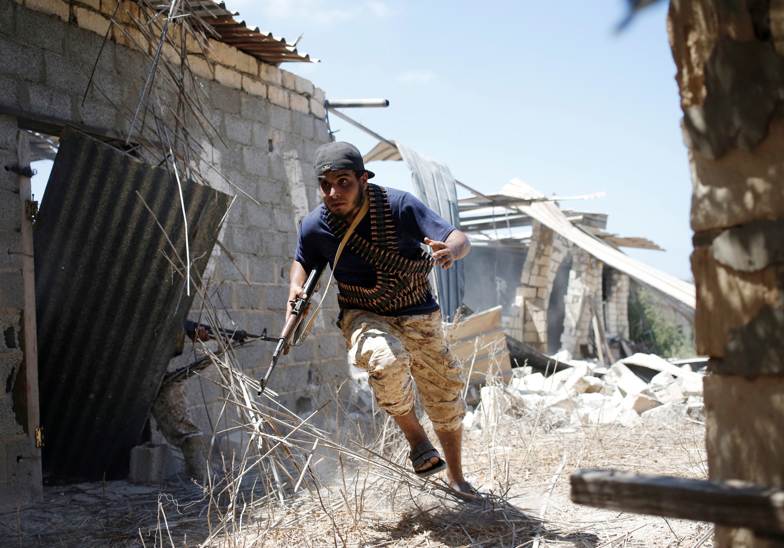 A fighter of Libyan forces allied with the U.N.-backed government runs for cover during a battle with Islamic State fighters in Sirte, Libya on July 31, 2016.