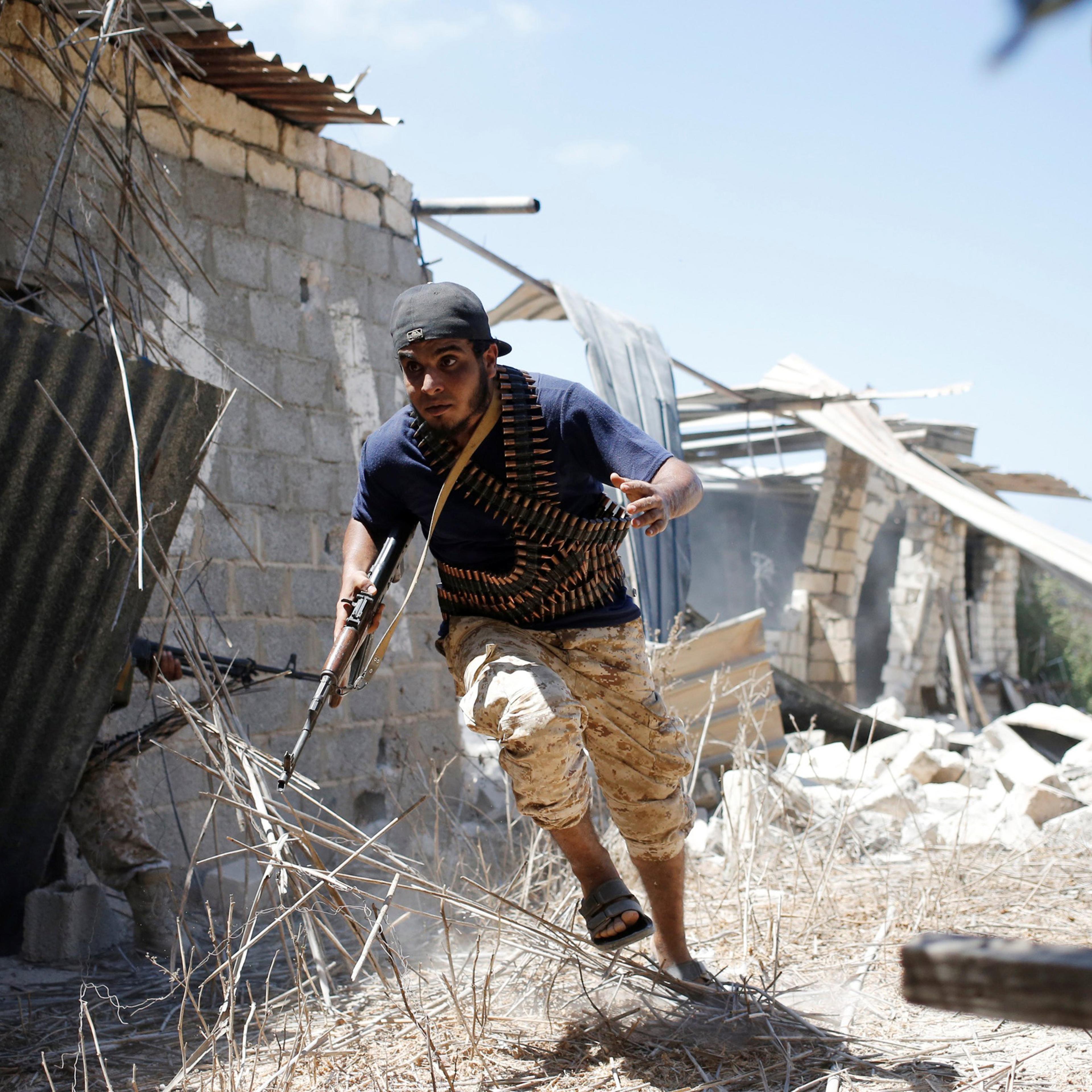 A fighter of Libyan forces allied with the U.N.-backed government runs for cover during a battle with Islamic State fighters in Sirte, Libya on July 31, 2016.