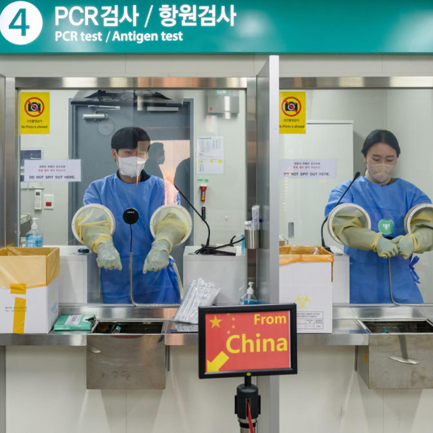 Quarantine officials seen preparing for a PCR test for travelers arriving from China in South Korea