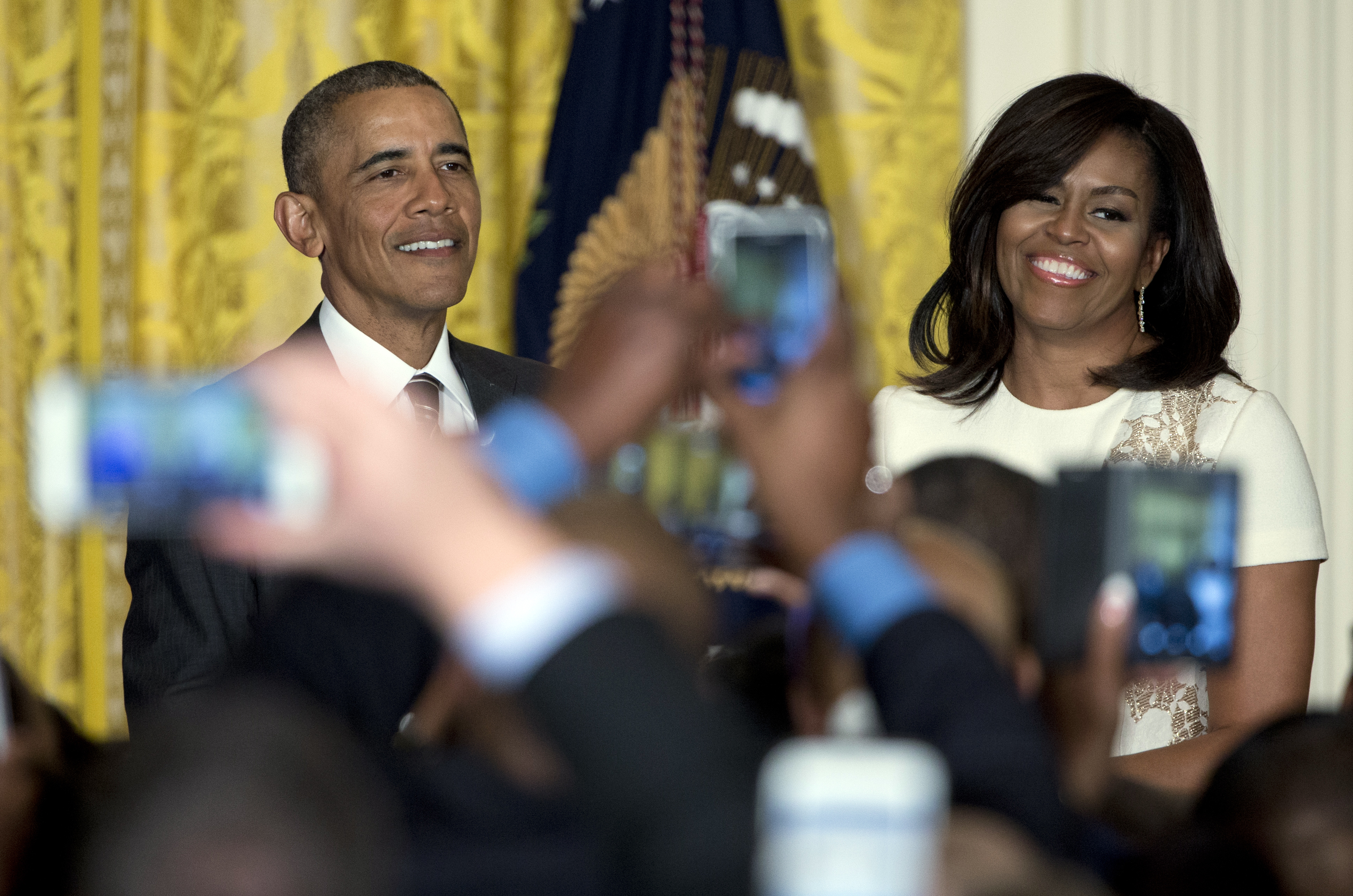 President Barack Obama and first lady Michelle Obama are seen above audience member cell phones as they host a reception celebrating African American History Month in the East Room of the White House in Washington on Feb. 18, 2016.