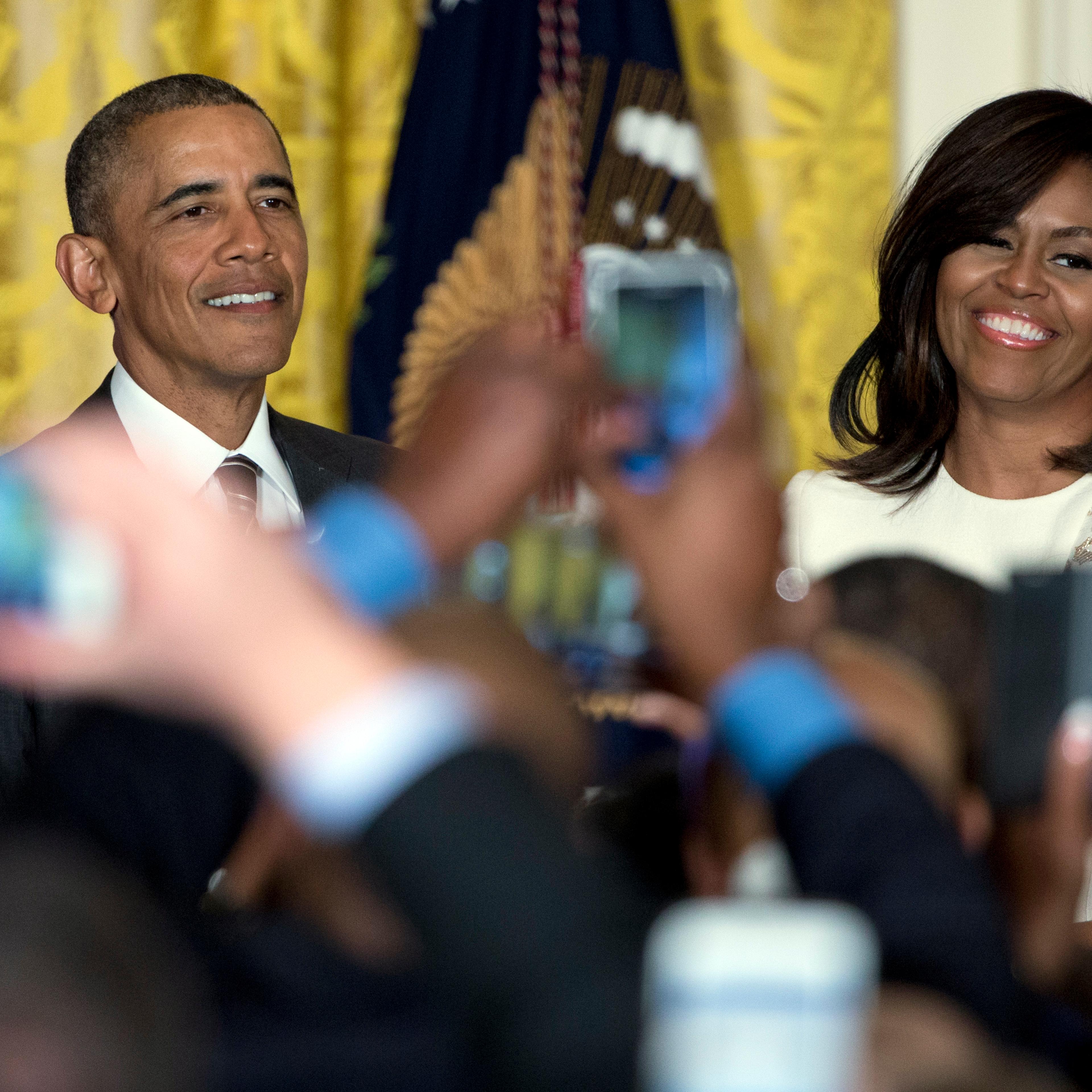 President Barack Obama and first lady Michelle Obama are seen above audience member cell phones as they host a reception celebrating African American History Month in the East Room of the White House in Washington on Feb. 18, 2016.