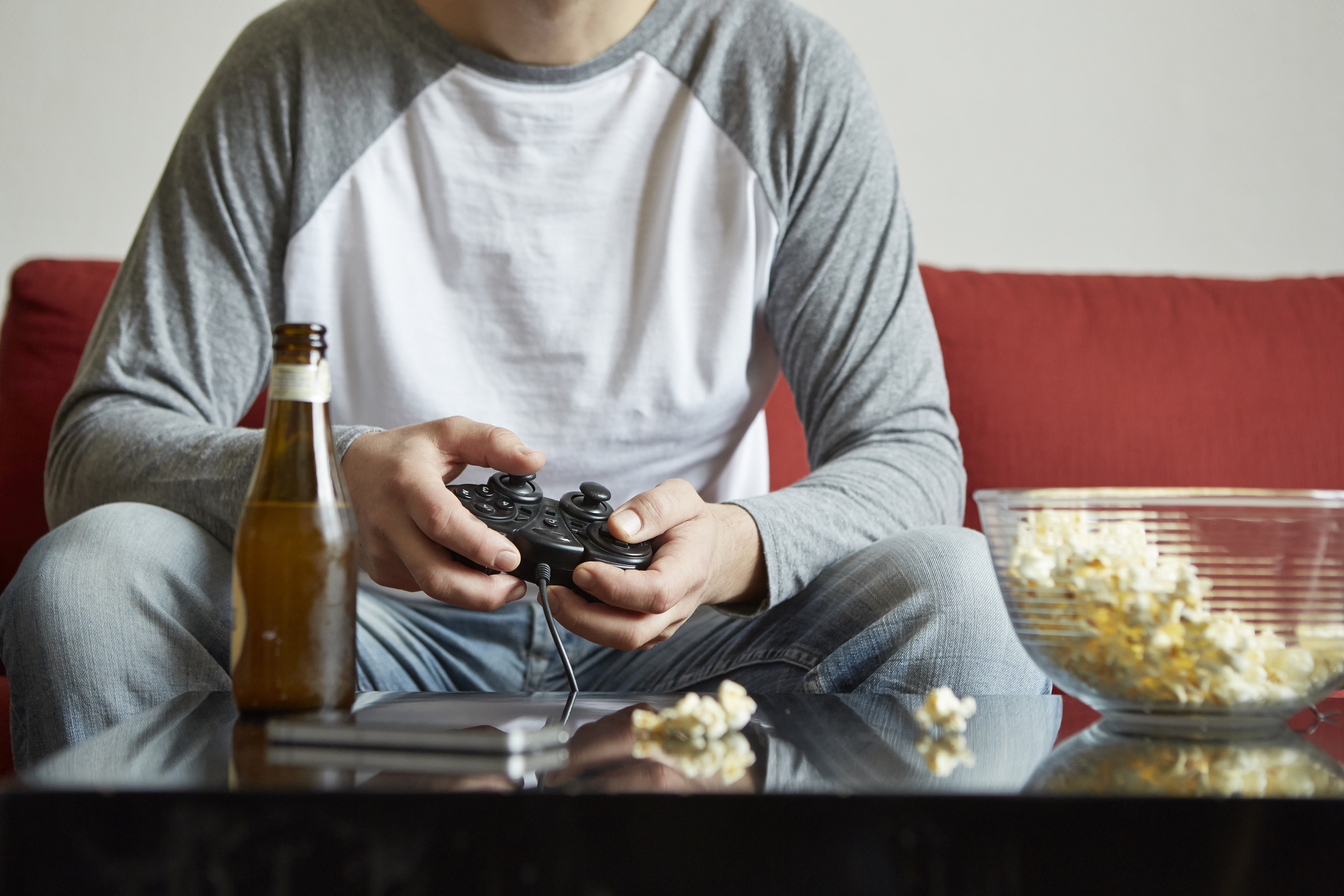 Mid adult man sitting on sofa using computer game control