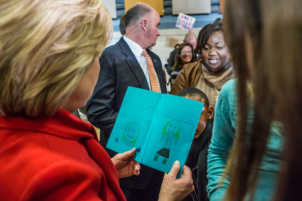 NORTH LIBERTY, IOWA - JANUARY 24: Democratic presidential candidate Hillary Clinton reads a card given to her by a young girl after a campaign event at Buford Garner Elementary School on January 24, 2016 in North Liberty, IA. The Democratic and Republica