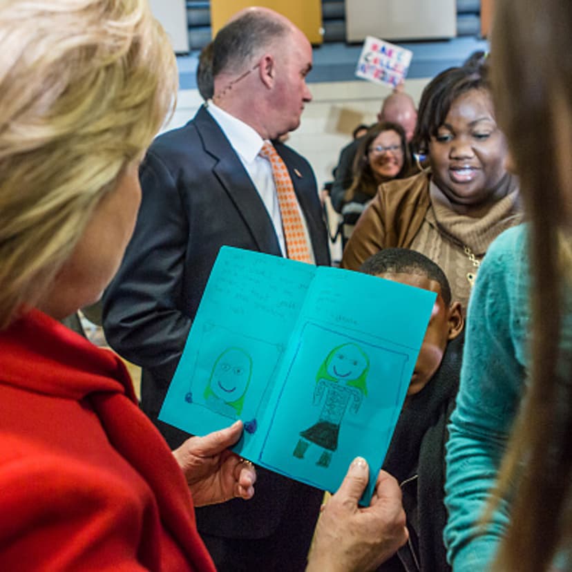 NORTH LIBERTY, IOWA - JANUARY 24: Democratic presidential candidate Hillary Clinton reads a card given to her by a young girl after a campaign event at Buford Garner Elementary School on January 24, 2016 in North Liberty, IA. The Democratic and Republica