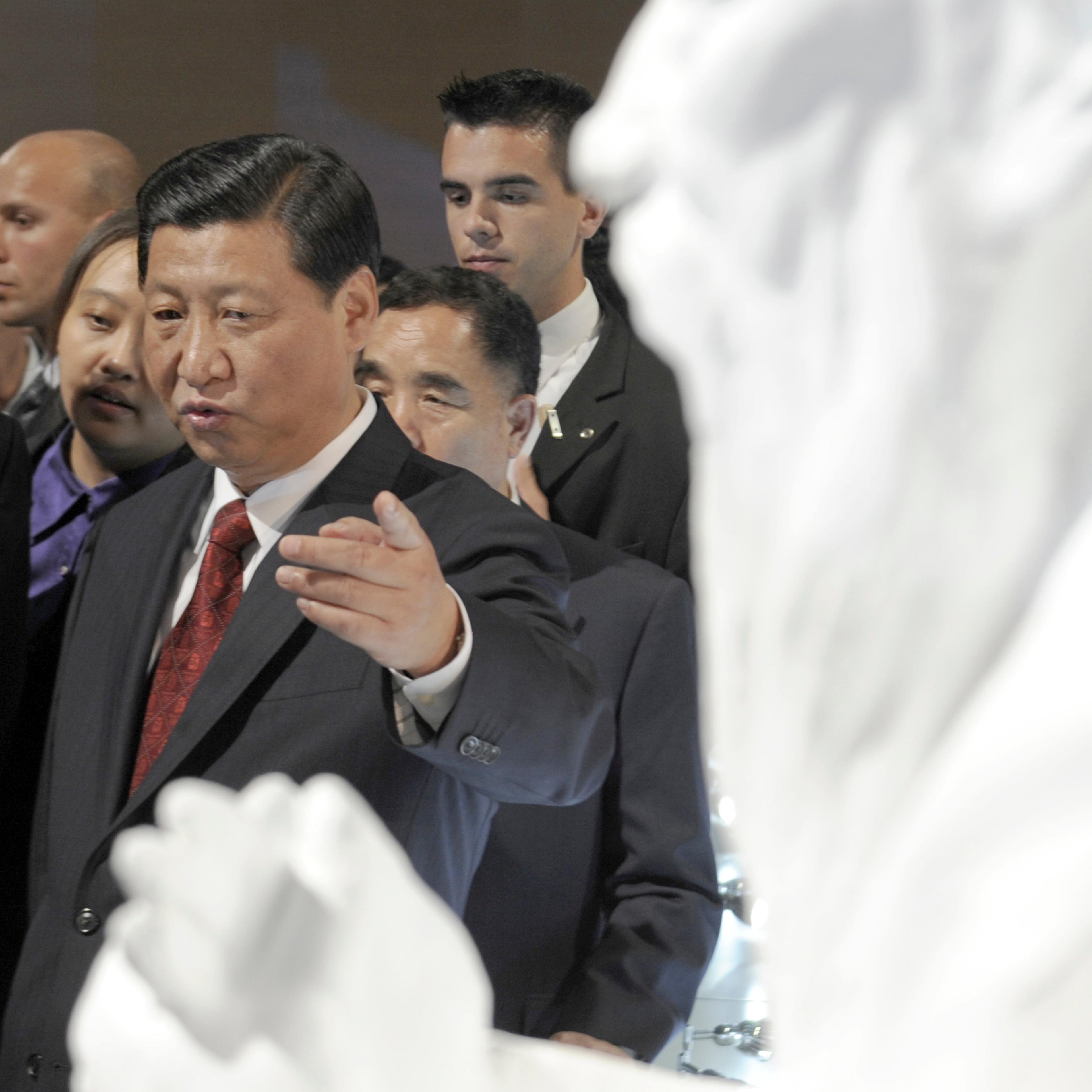 China's Vice President Xi Jinping points at the bust of Confucius in China pavilion of Frankfurt book fair