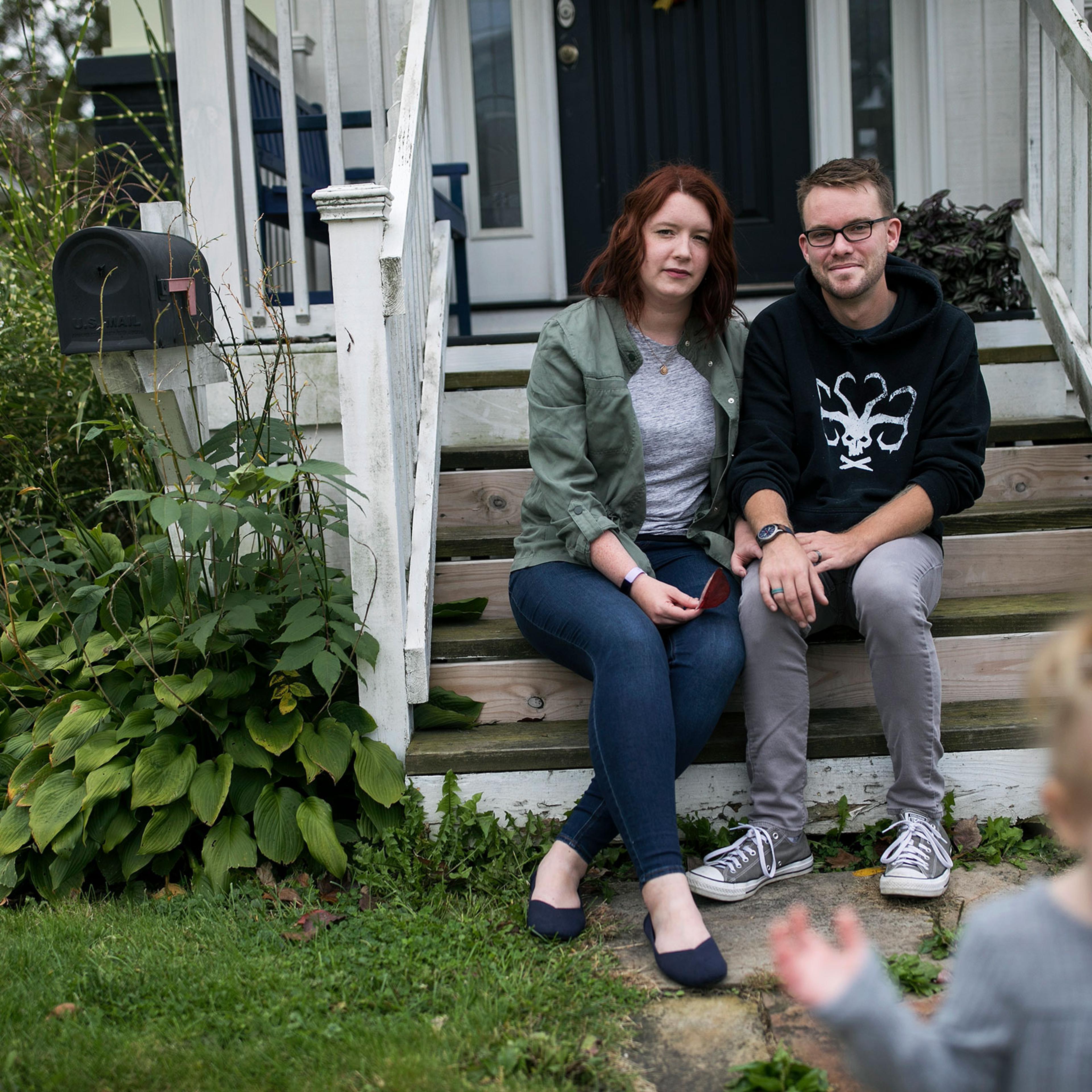 Shelby Parker sits outside of her home with her husband Ben and daughter Abby in Cuyahoga Falls, Ohio on Oct. 3, 2020. Parker planned to get pregnant this year, but is contemplating not trying for a second child at all now due to the coronavirus.