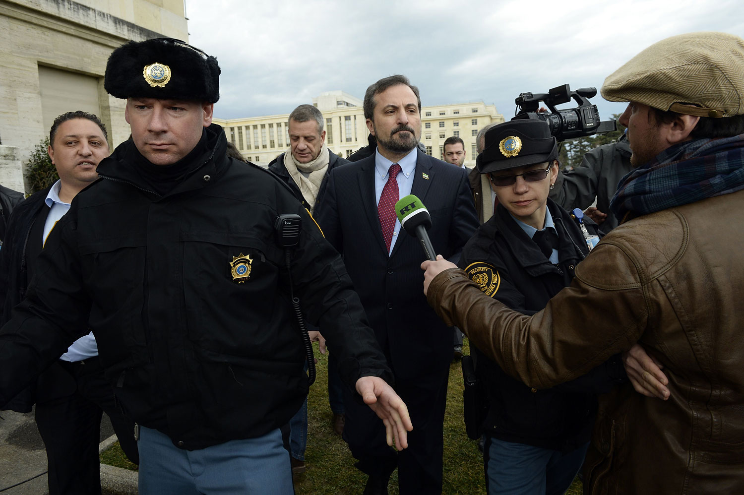 The spokesperson for the Syrian National Coalition Louay Safi leaves after a press conference on the Syrian peace talks escorted by United Nations (UN) police at the UN headquarters in Geneva on February 15, 2014.