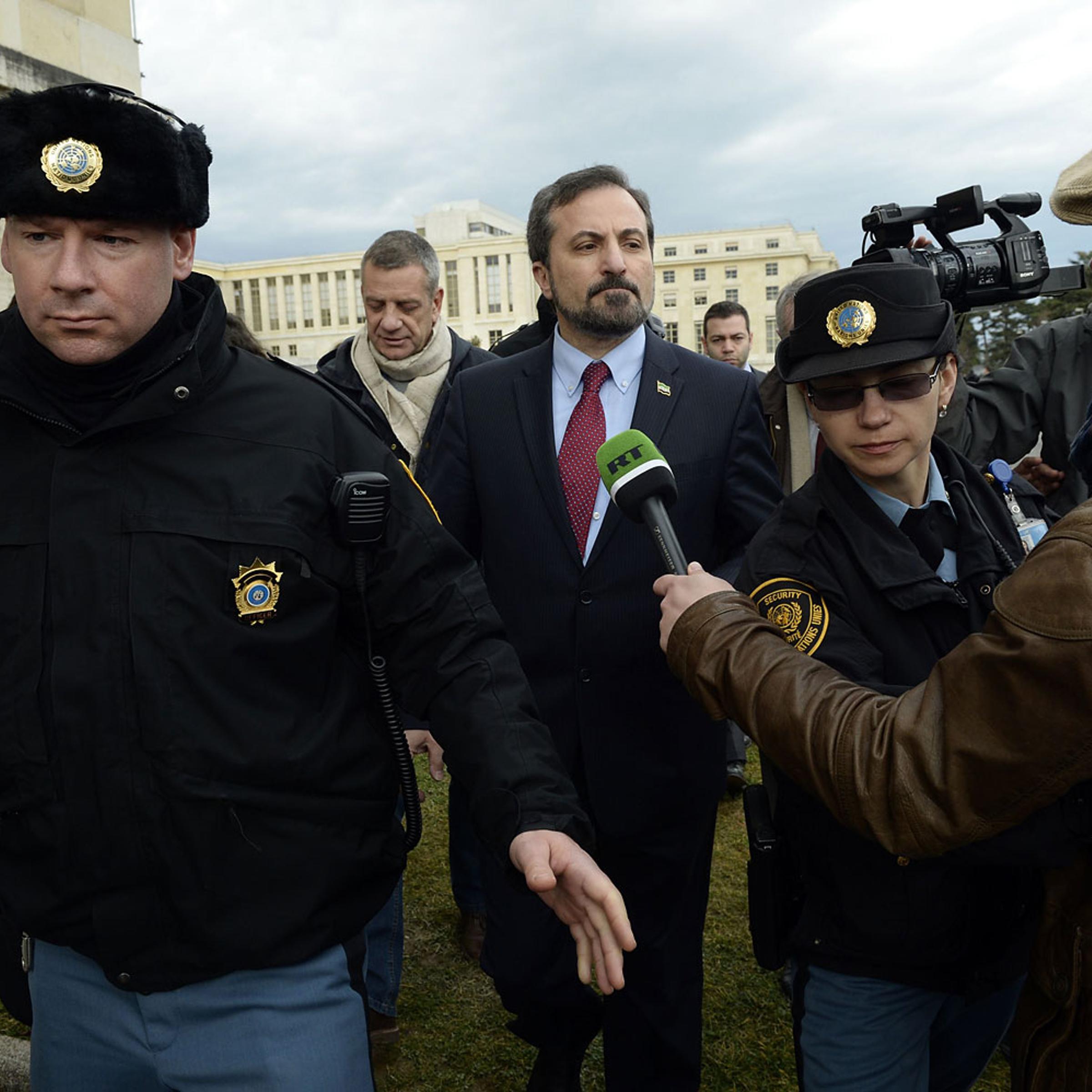 The spokesperson for the Syrian National Coalition Louay Safi leaves after a press conference on the Syrian peace talks escorted by United Nations (UN) police at the UN headquarters in Geneva on February 15, 2014.