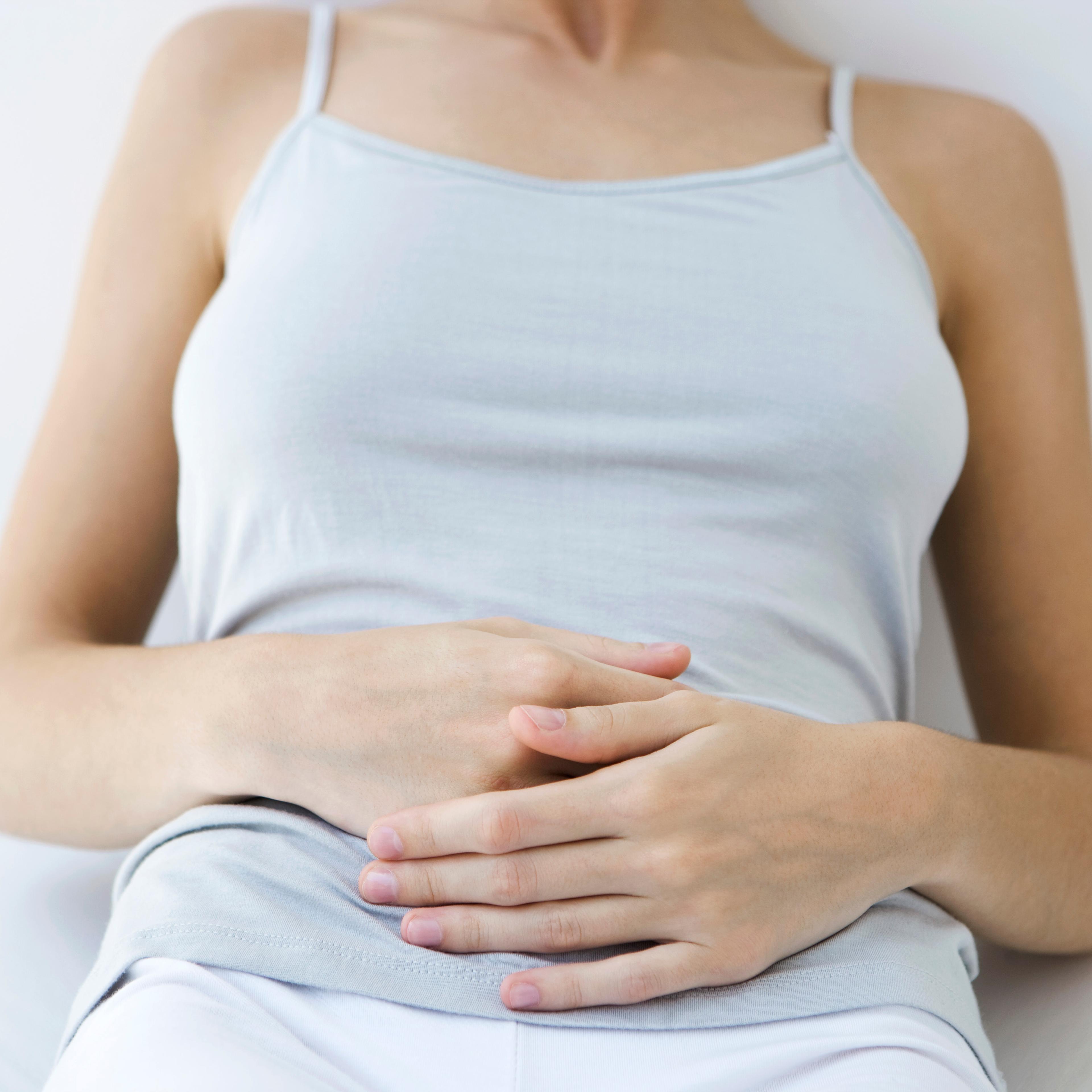 Woman holding stomach, cropped view