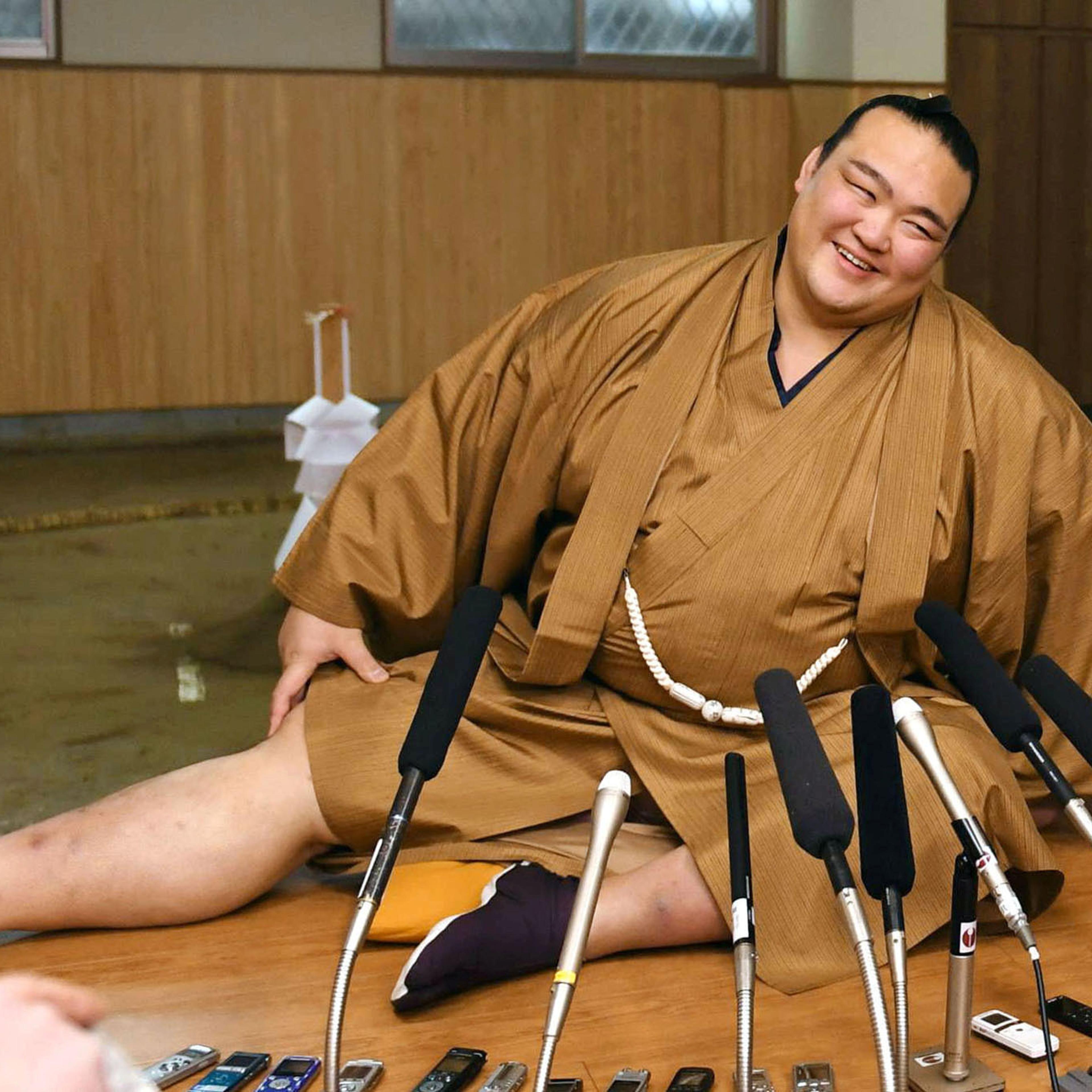 New Year Grand Sumo Tournament winner ozeki Kisenosato stretches his legs during a press conference at his Tagonoura stable in Tokyo