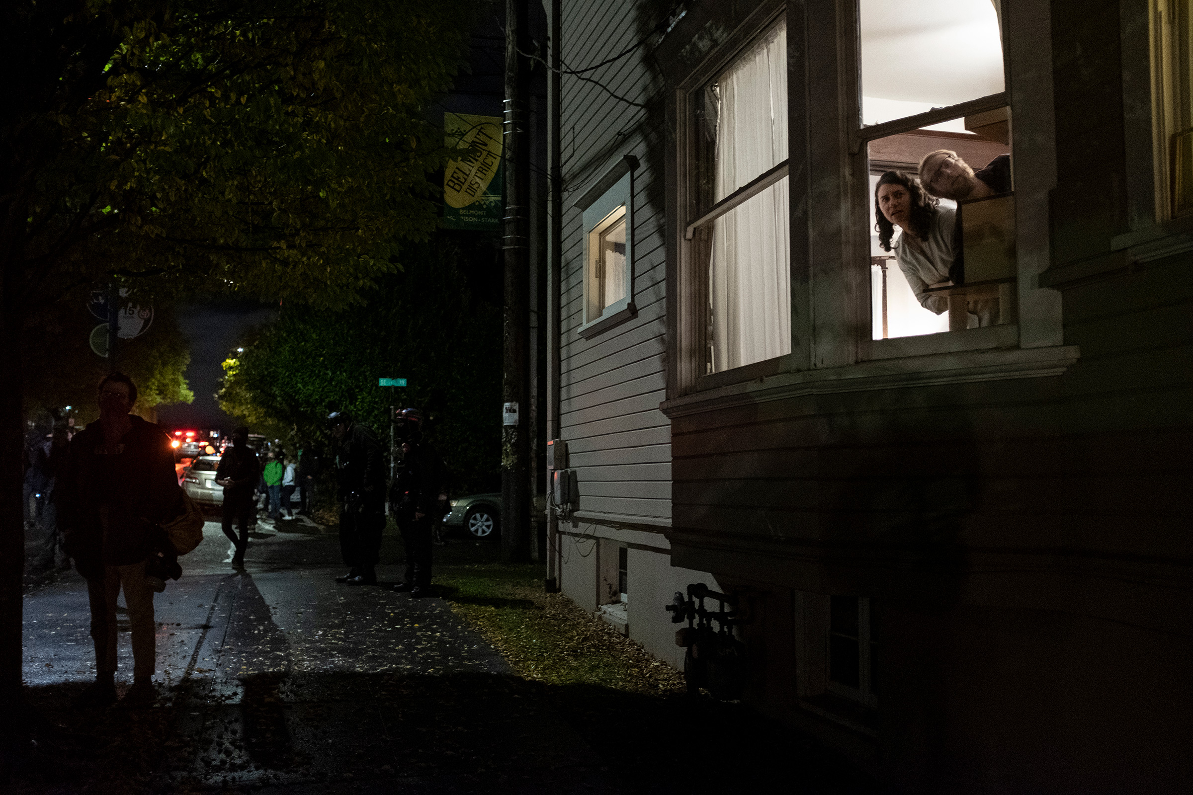 Residents watch a Black Lives Matter protest march through their neighborhood on election day in Portland, Ore., Nov. 3, 2020.