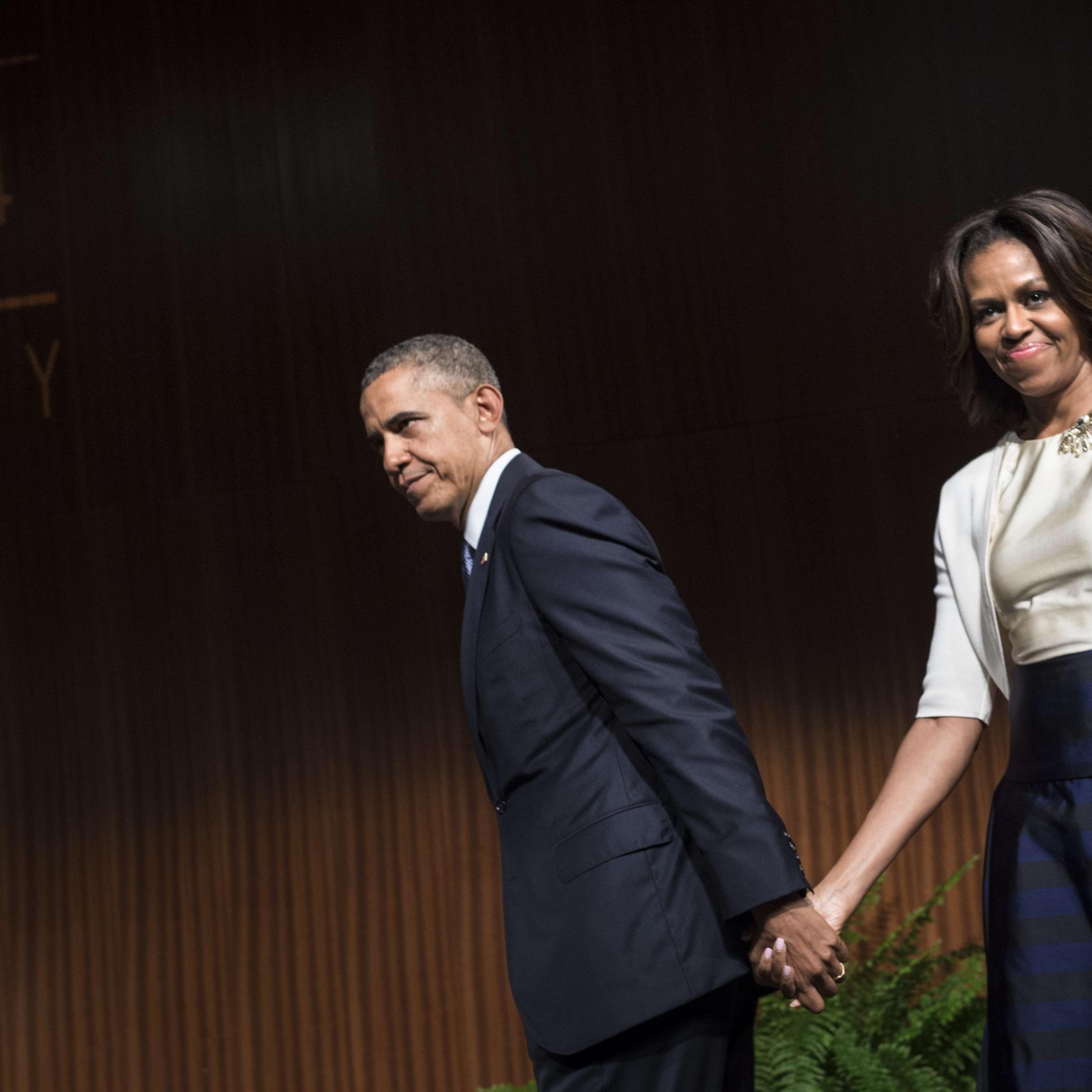 President Barack Obama leaves with first lady Michelle Obama after speaking at the Lyndon B. Johnson Presidential Library in Austin, Texas.