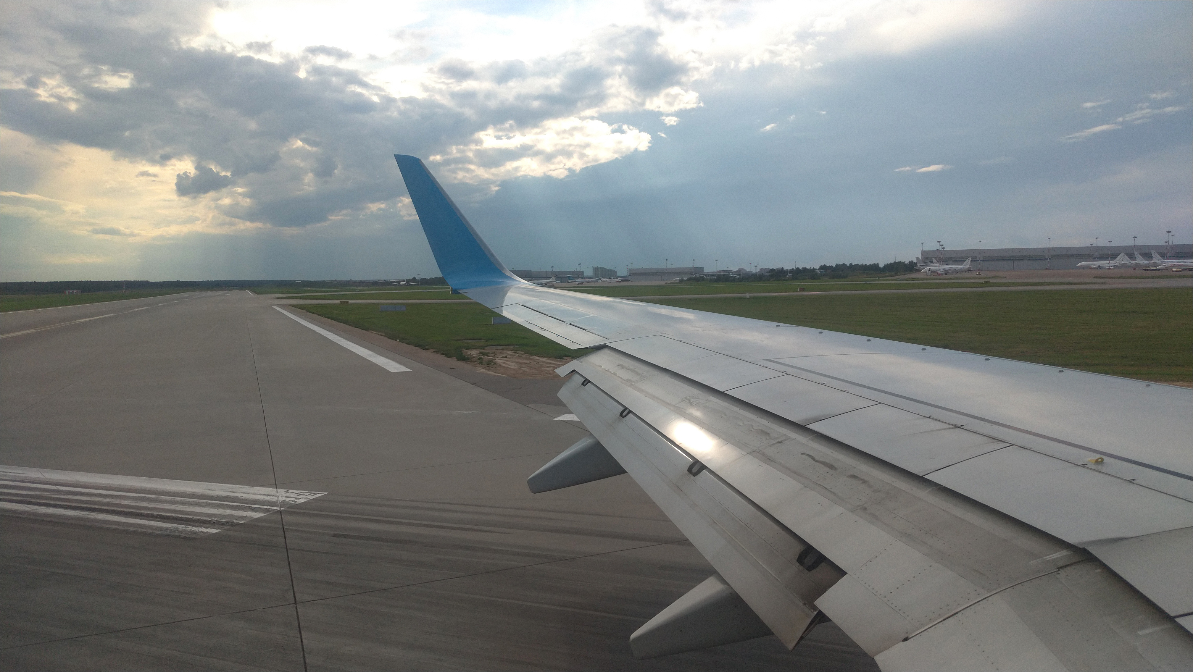 Airplane wing view out of the window on the cloudy sky The Earth background. Holiday vacation background. Wing of airplane flying above the clouds in the sky. Landing airplane, Moscow, Russia