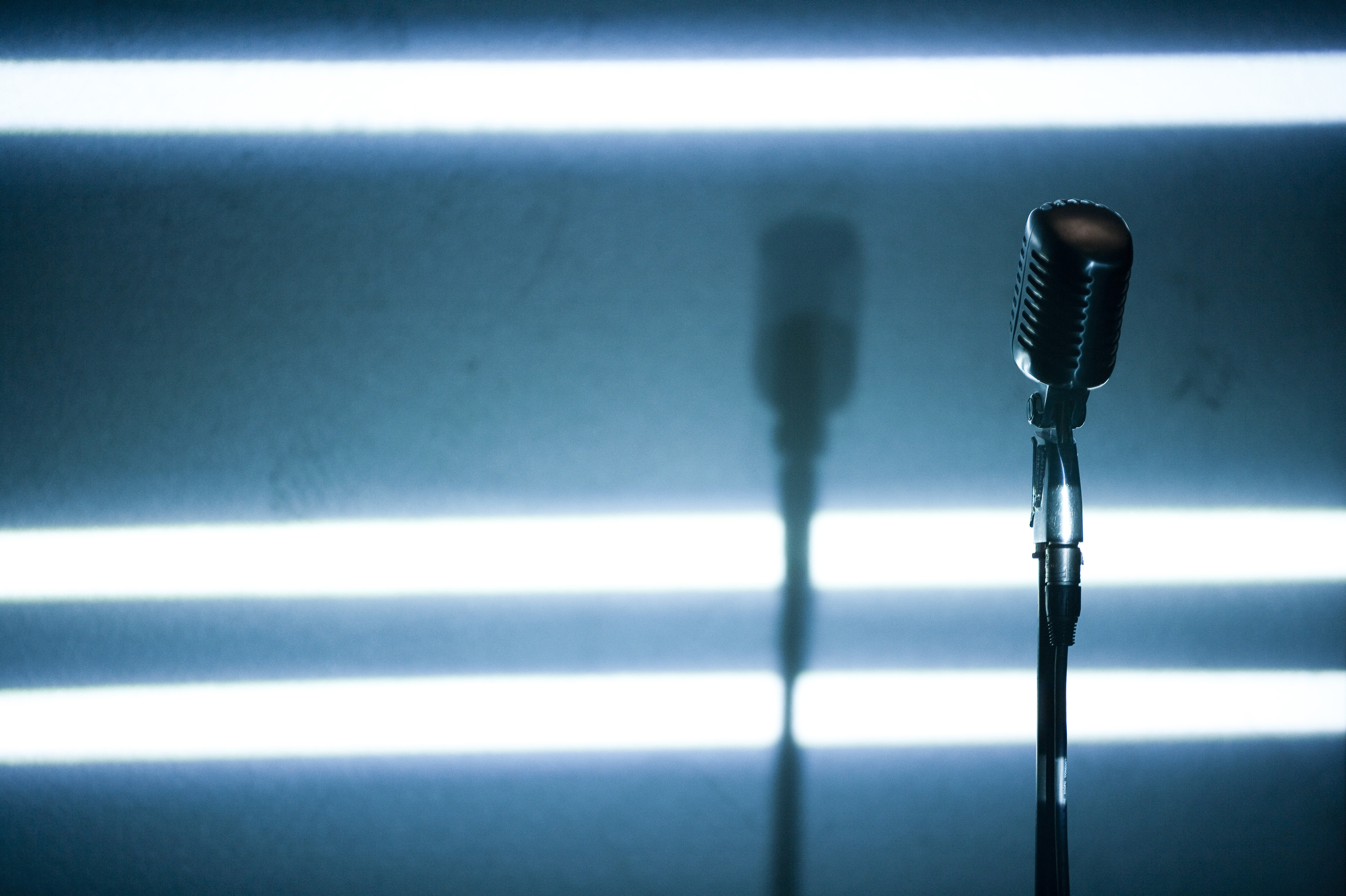 A microphone backlit on a stage
