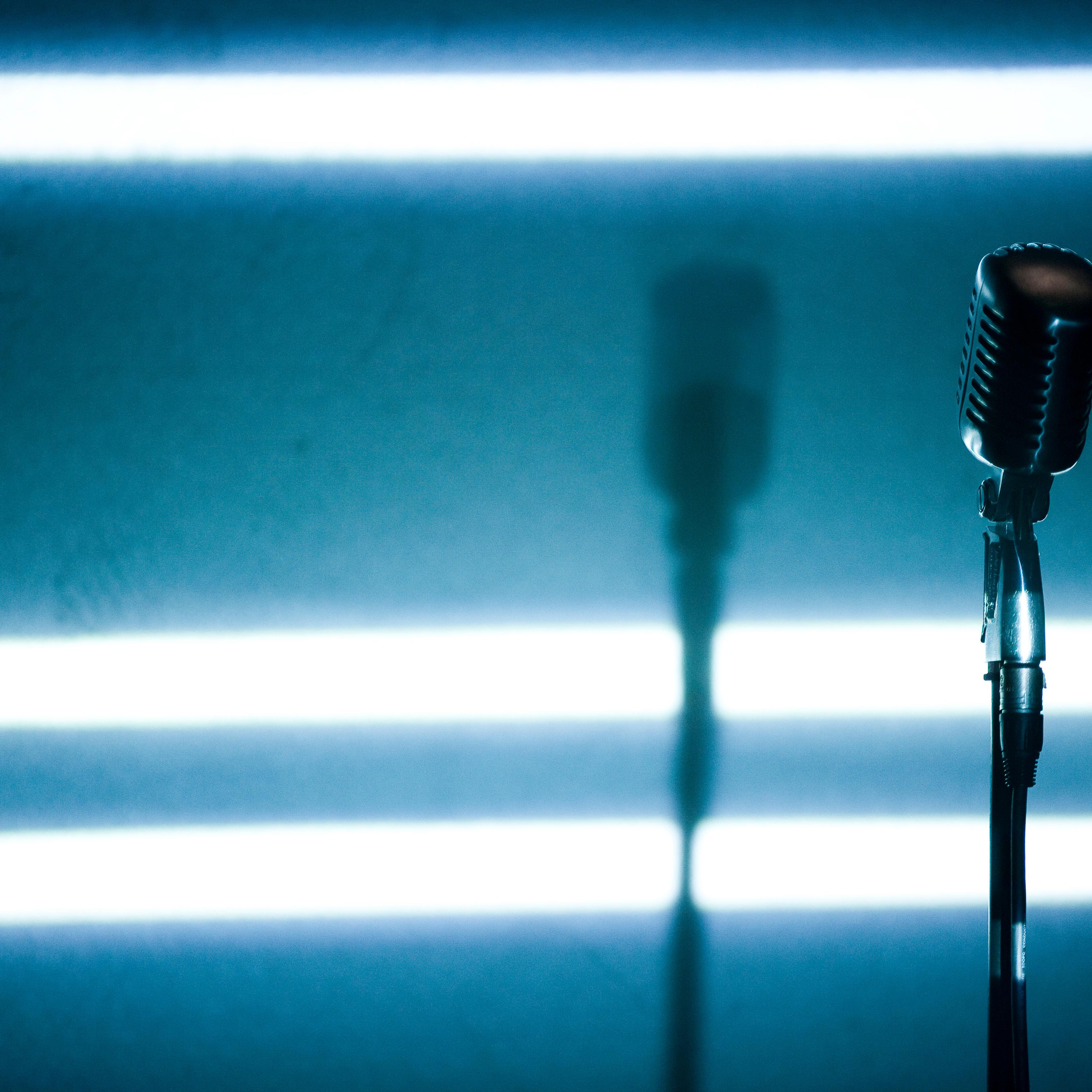 A microphone backlit on a stage