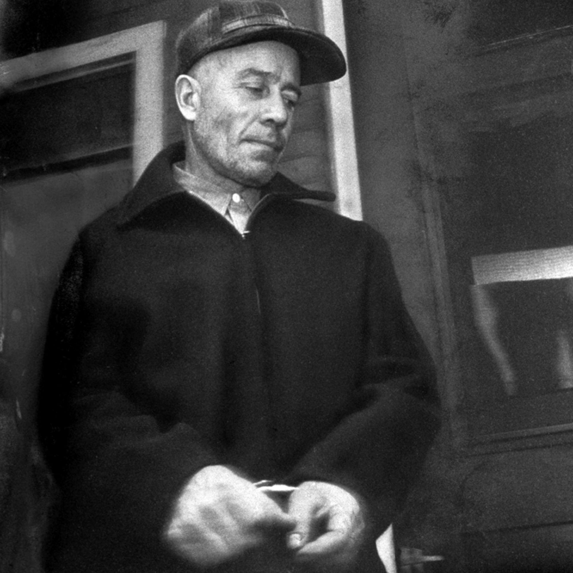 Killer Ed Gein, being led away from his house in handcuffs, Plainfield, Wis., 1957.