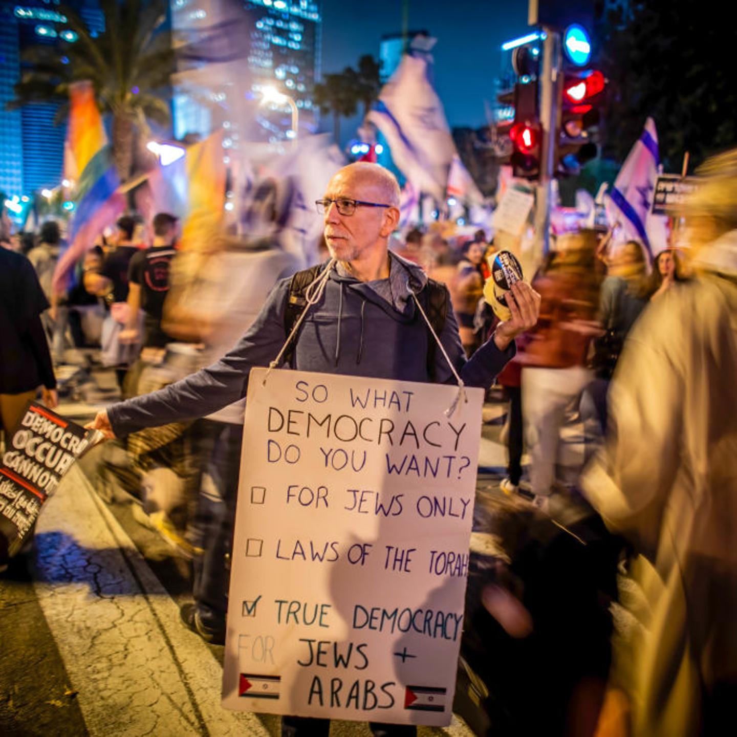 A protester holds placards expressing his opinions during