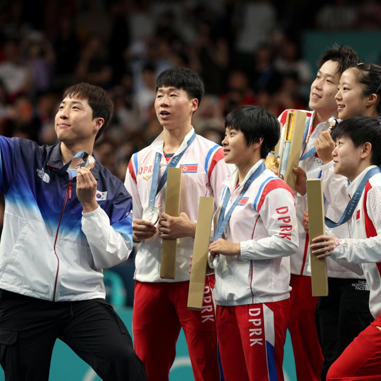 Table tennis medalists representing China, North Korea, and South Korea pose for a selfie on the podium after mixed doubles final at South Paris Arena on July 30, 2024.
