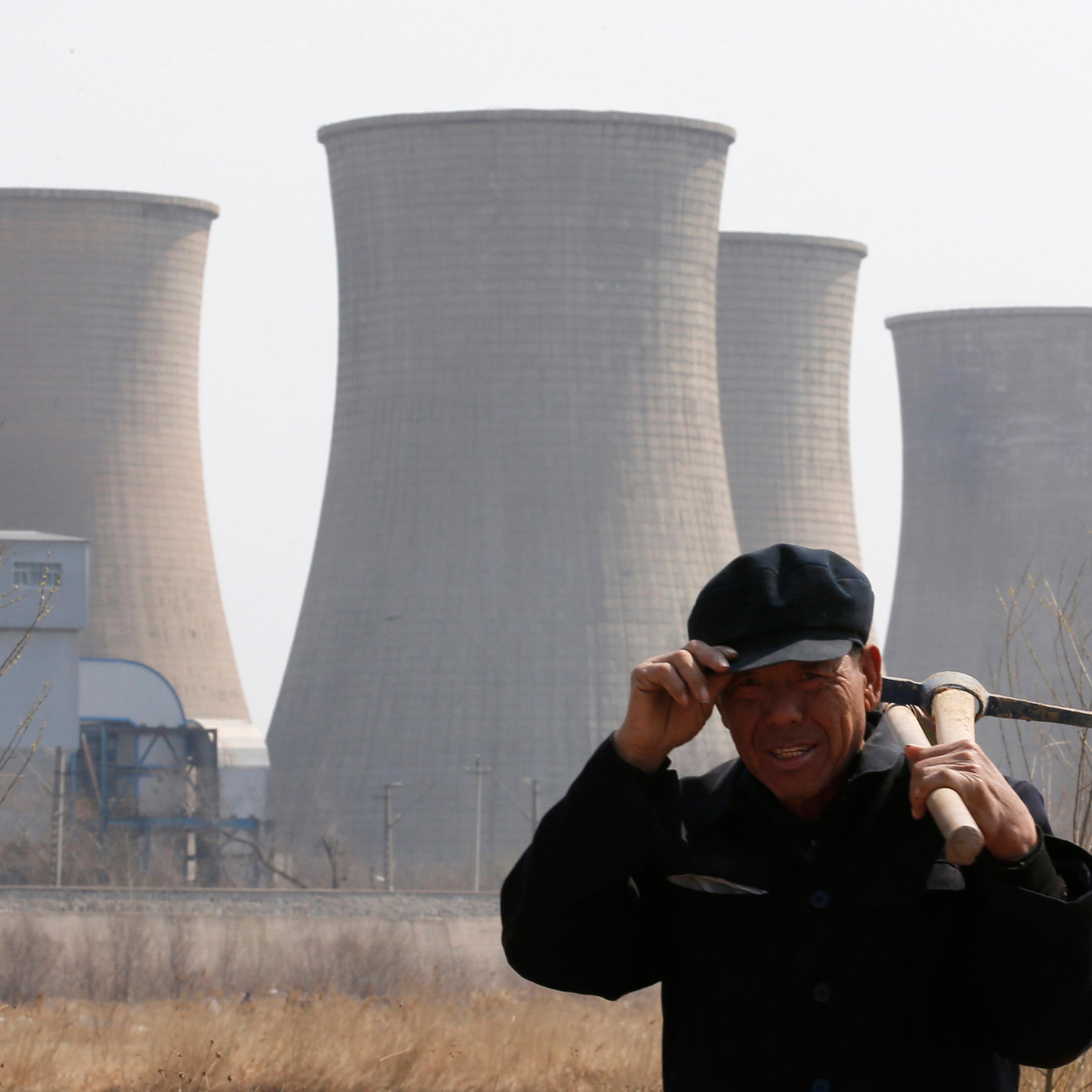 A worker walks past a steel factory in Beijing