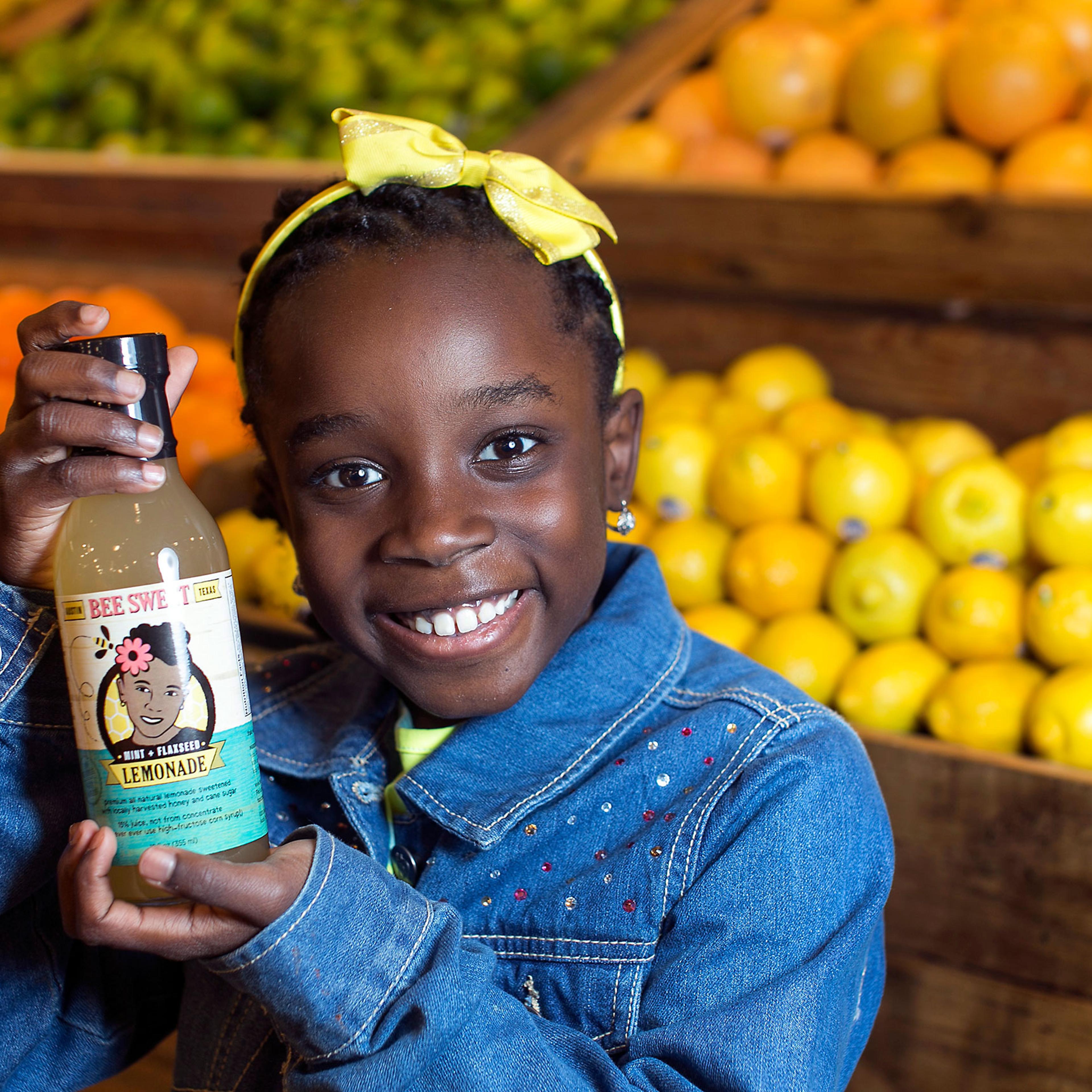 In this Jan. 27, 2014, photo, Mikaila Ulmer stands for a photo as she holds a bottle of Bee Sweet Lemonade that she and her family make and sell at Whole Foods at the Domain in Austin, Texas.