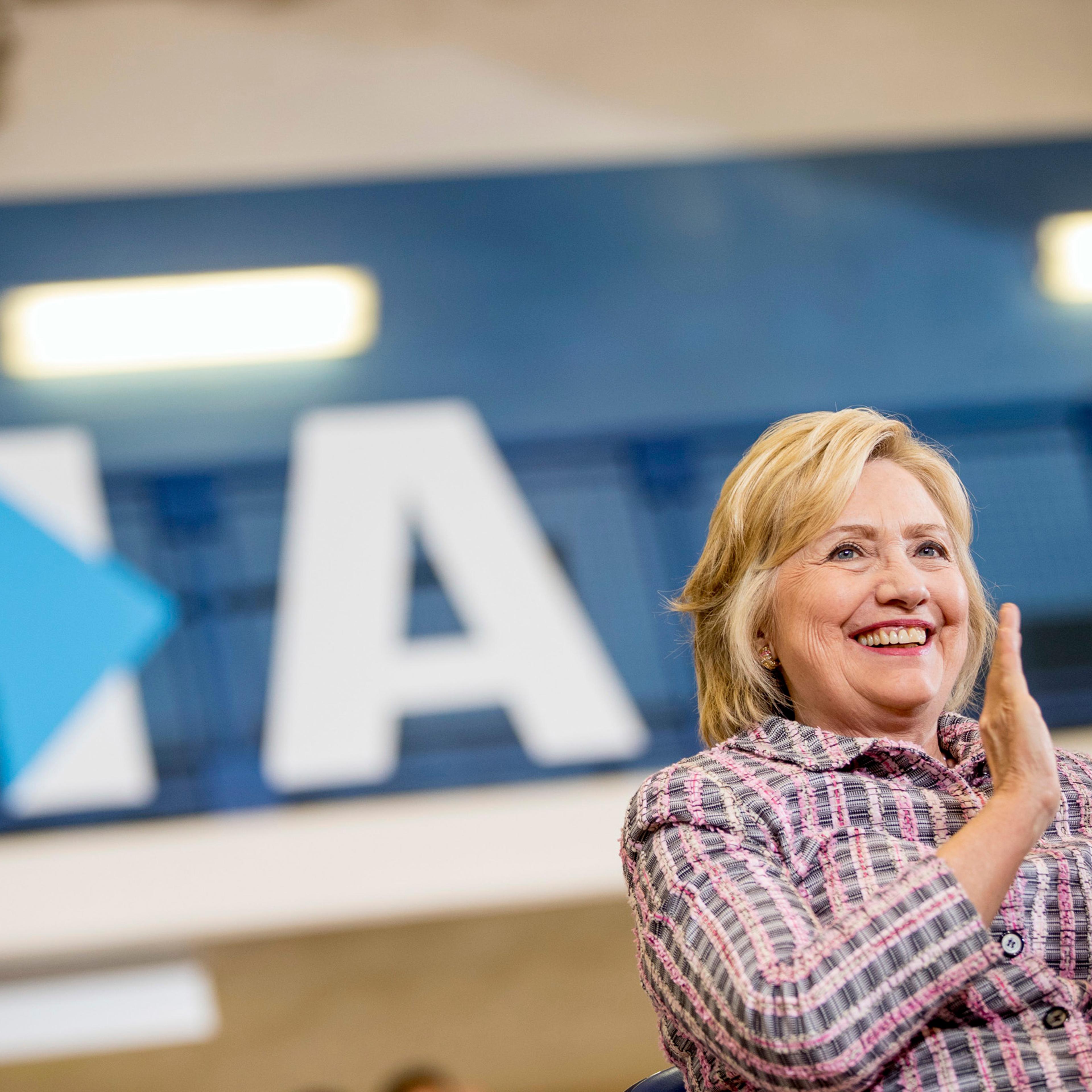 Democratic presidential candidate Hillary Clinton applauds as she sits on stage at a rally at Omaha North High Magnet School in Omaha, Neb. on Aug. 1, 2016.