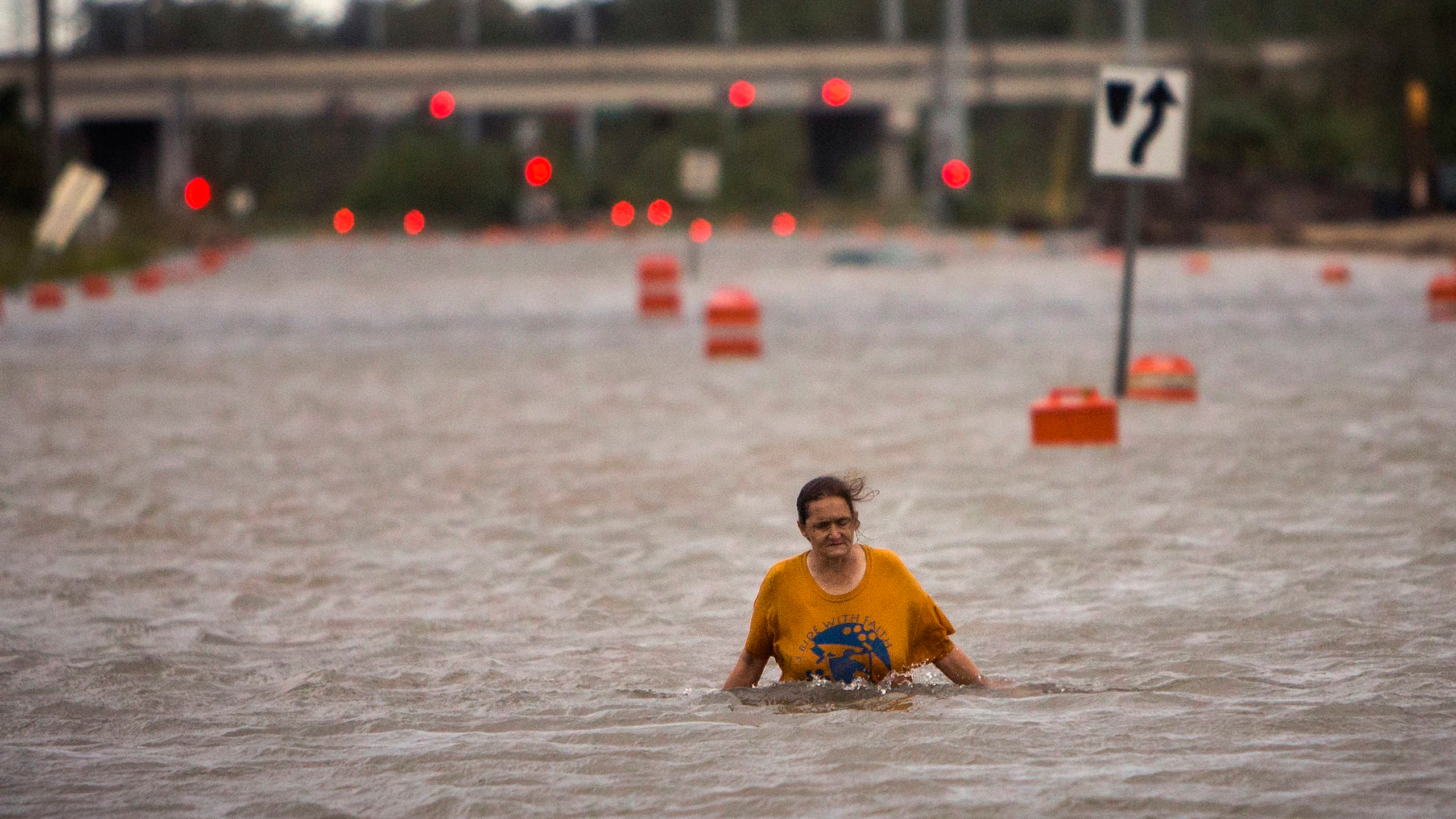 A woman who identified herself as Valerie walks along flooded President Street after leaving her homeless camp after Hurricane Matthew caused flooding, Saturday, Oct. 8, 2016, in Savannah, Ga. Matthew plowed north along the Atlantic coast, flooding towns