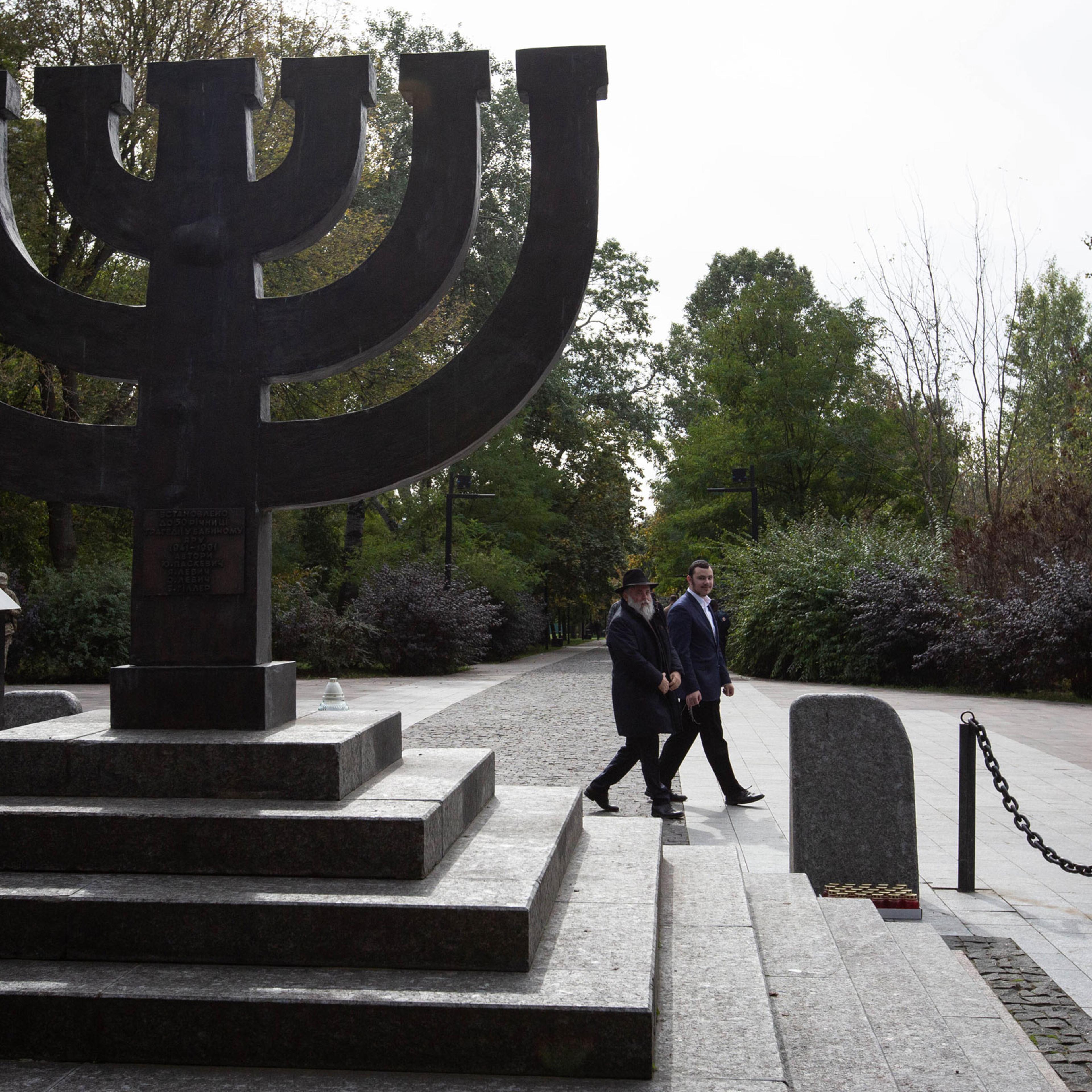 A rabbi walks past a monument commemorating the victims of Babyn Yar in Kyiv