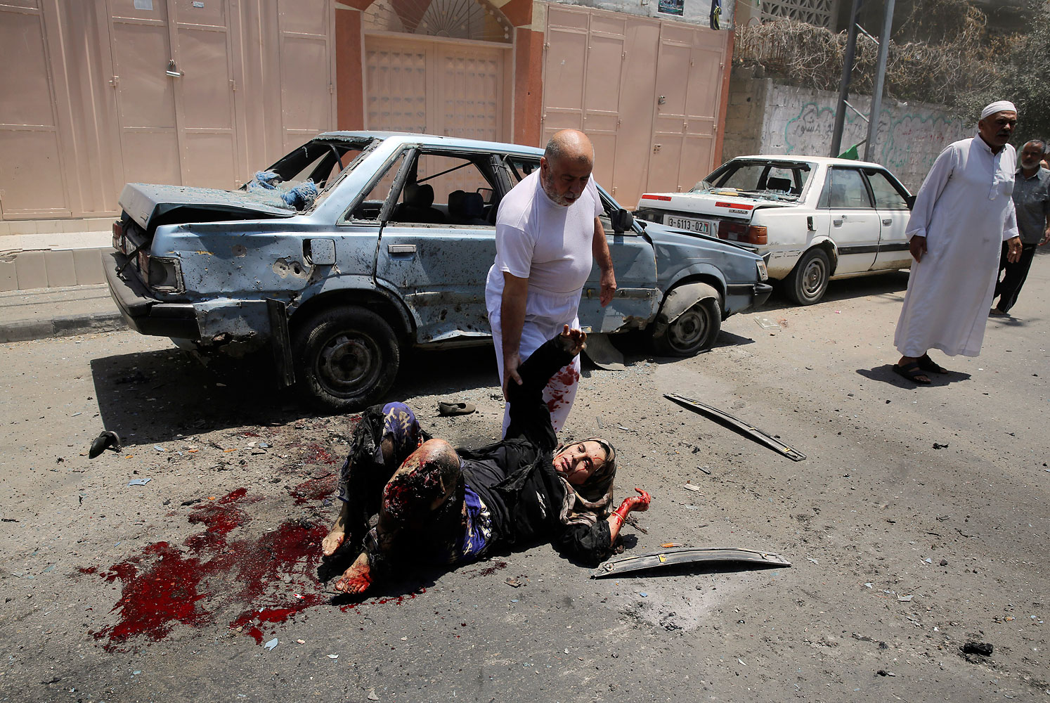 Palestinian man holds the hand of a woman, who medics said was wounded in an Israeli air strike, in the northern Gaza Strip
