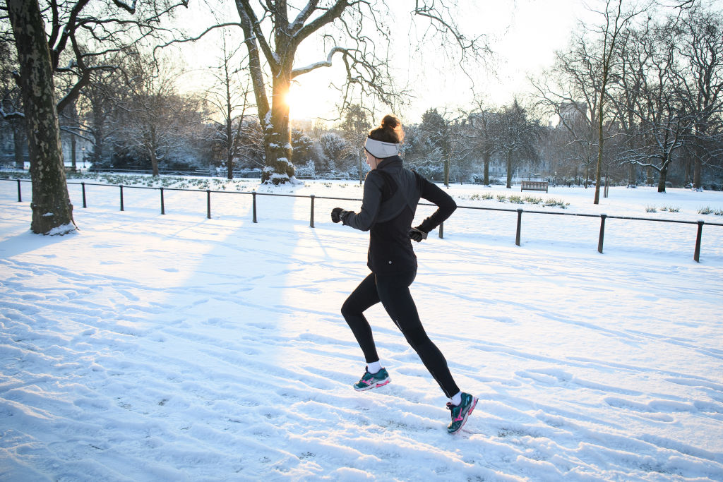 A jogger runs through the snow in St James' Park in London