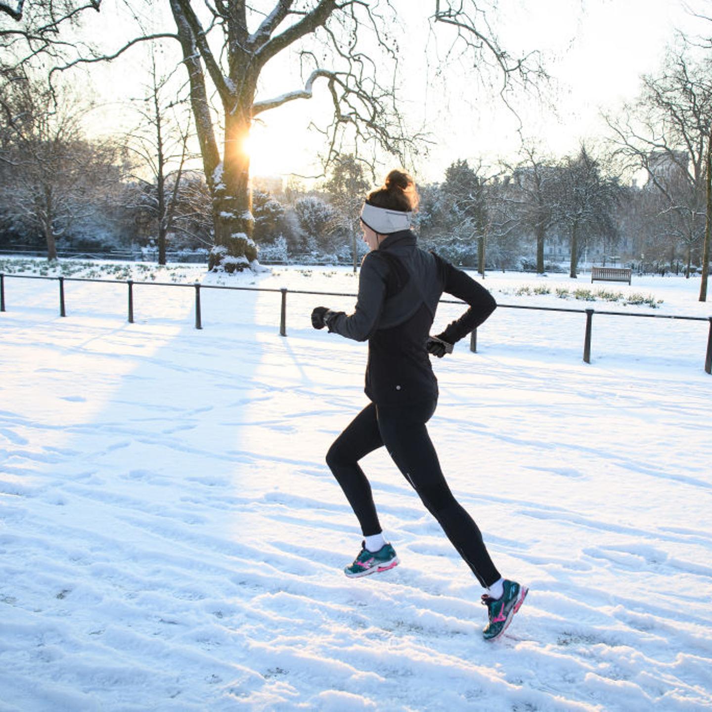 A jogger runs through the snow in St James' Park in London