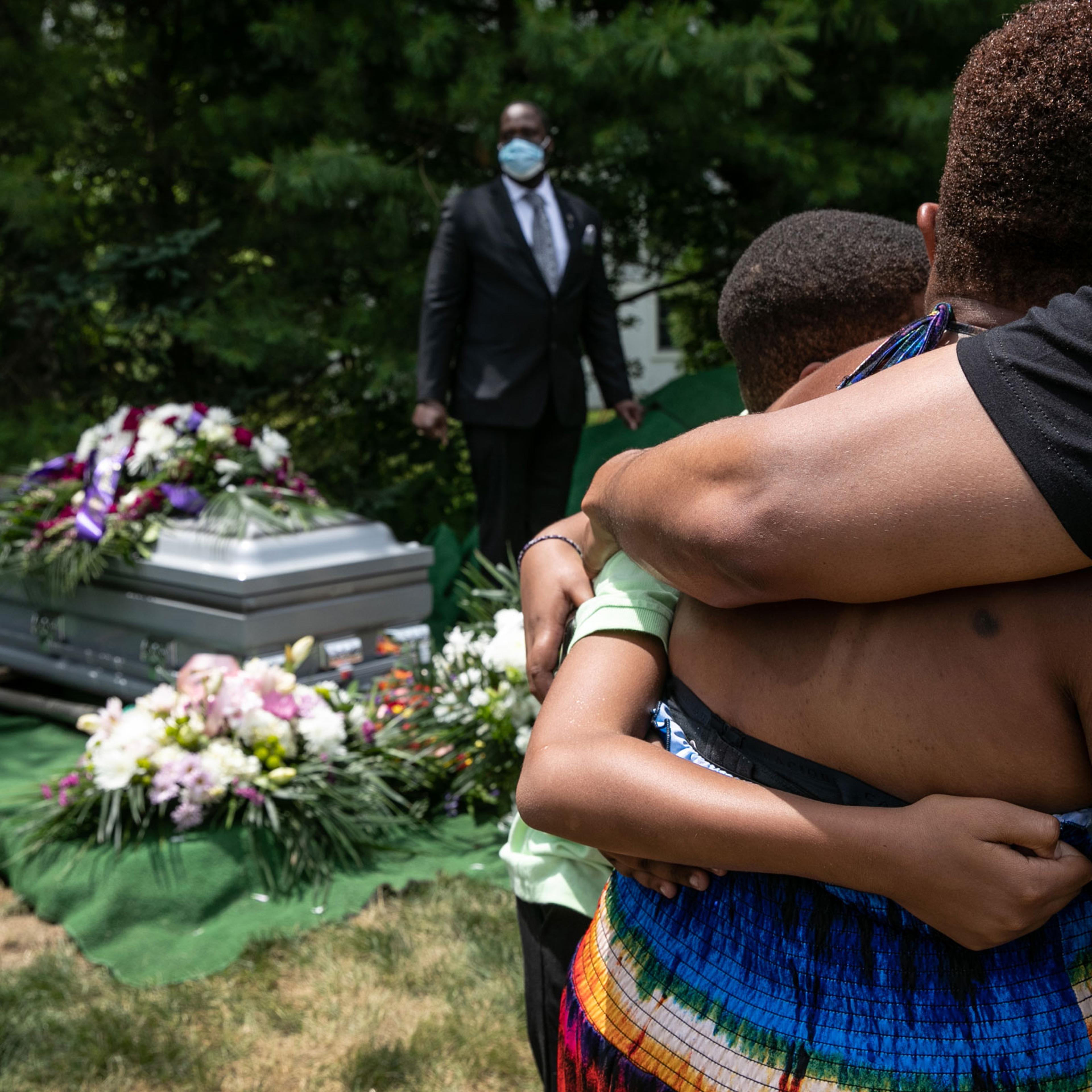 Family members and friends mourn the death of Conrad Coleman Jr. at his burial service
