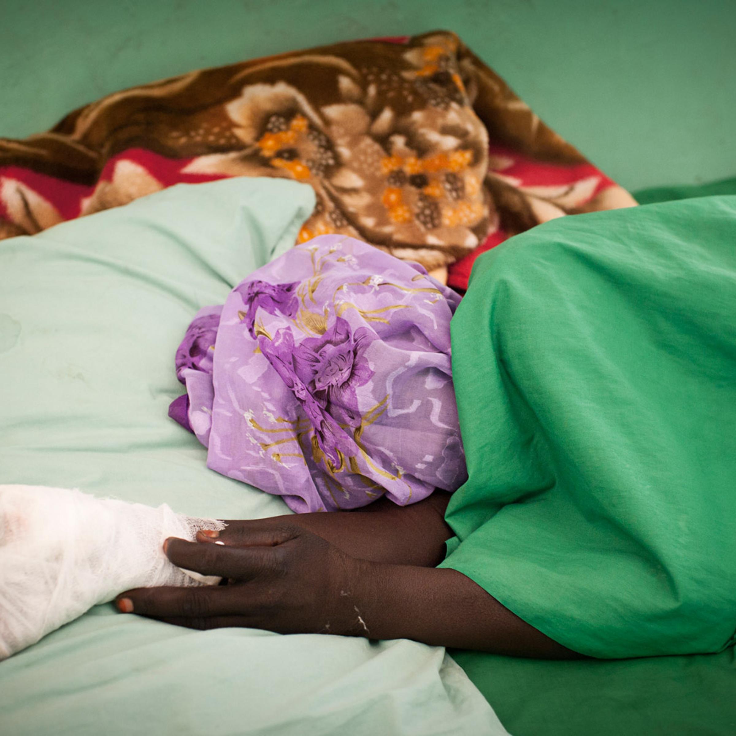 A civilian wounded after her village was bombed by northern Sudanese aircraft rests inside a hospital in the Nuba Mountains, July 2, 2011.