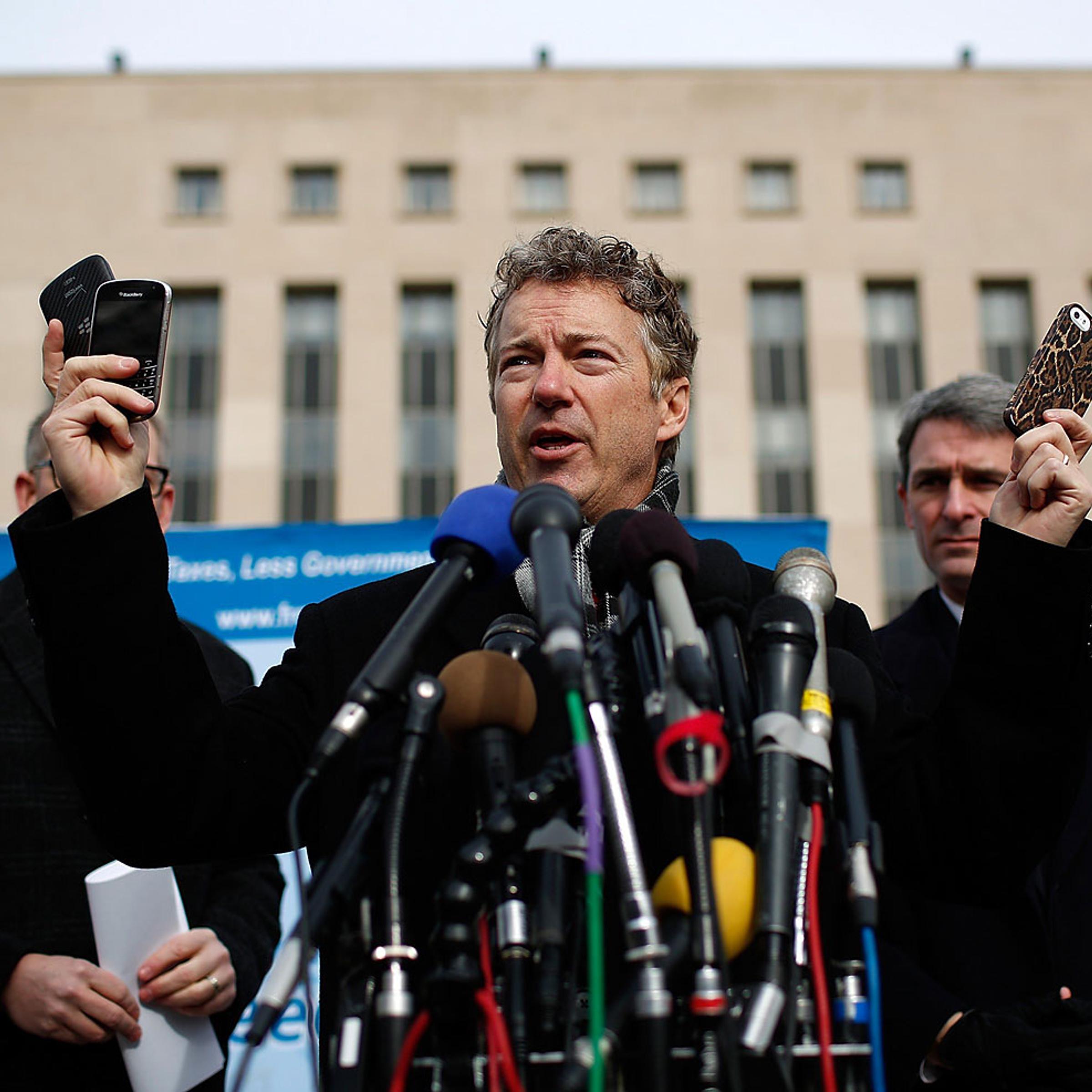 Sen. Rand Paul holds up a group of cell phones in front of U.S. District Court to announce the filing of a class action lawsuit against the administration of U.S. President Barack Obama, Feb. 12. 2014.