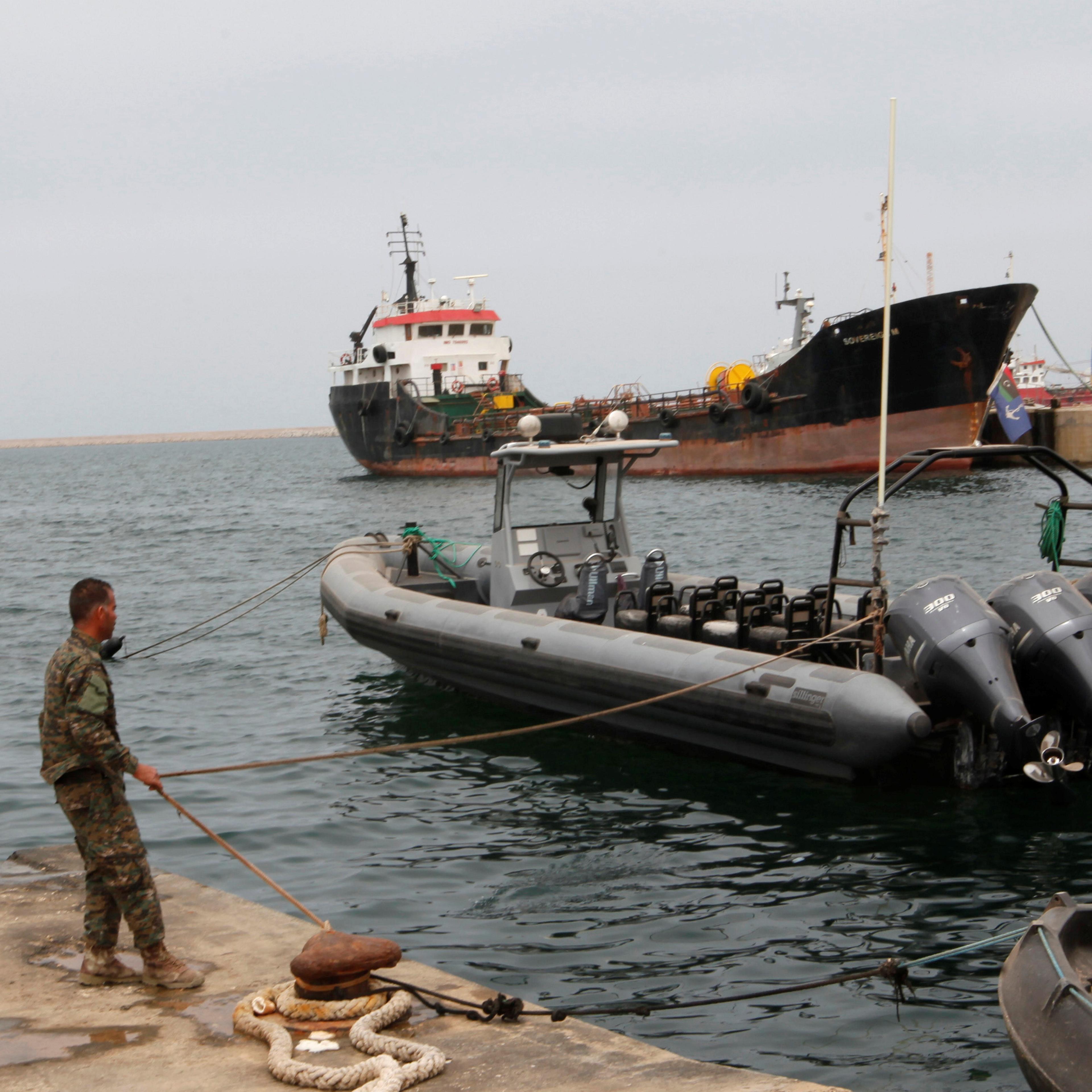 A member of the Libyan coast guard conducts a daily routine check on one of the patrol boats in Tripoli